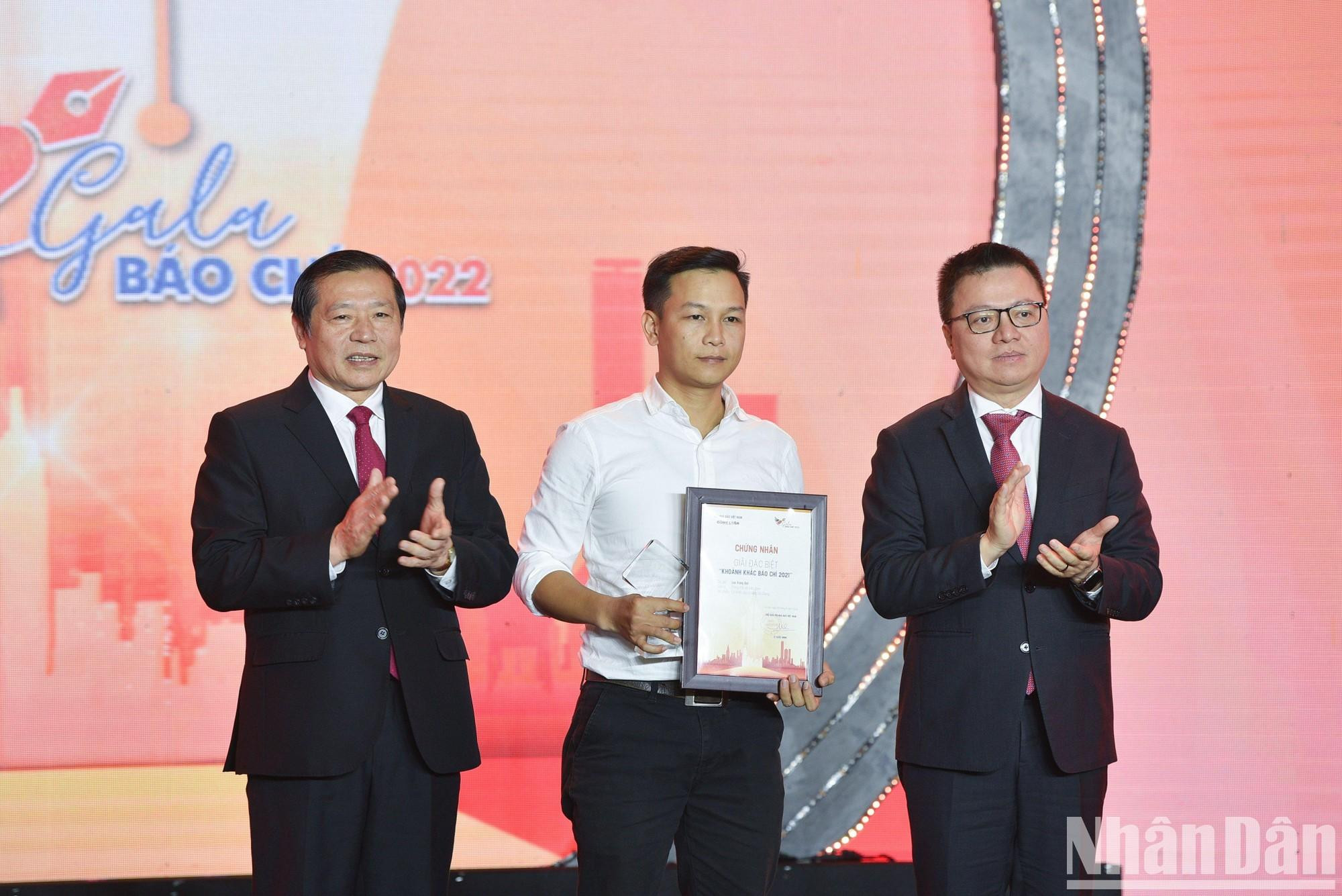 Le Quoc Minh y el subjefe permanente de su Comisión de Comunicación y Educación, Lai Xuan Mon, entregan el premio especial para Luu Trong Dat por su obra “Invocación del arroyo Da Giang”.