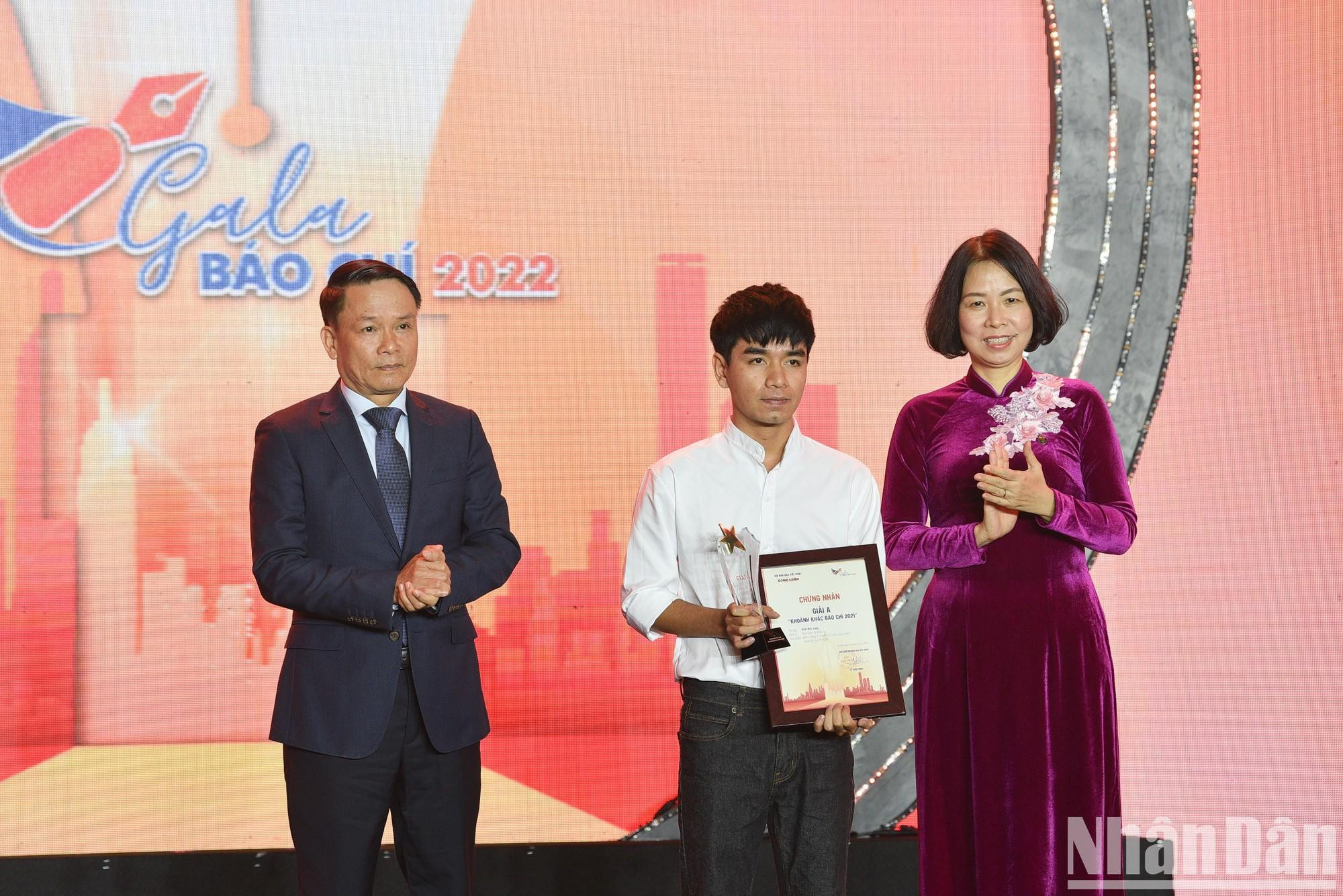 La directora general de la Agencia Vietnamita de Noticias, Vu Viet Trang, y el vicepresidente permanente de la Asociación de Periodistas de Vietnam, Nguyen Duc Loi, otorgan el premio A al autor Dinh Duc Long por su obra “Noche sin dormir en la última fortaleza contra el Covid-19 en Ciudad Ho Chi Minh”.