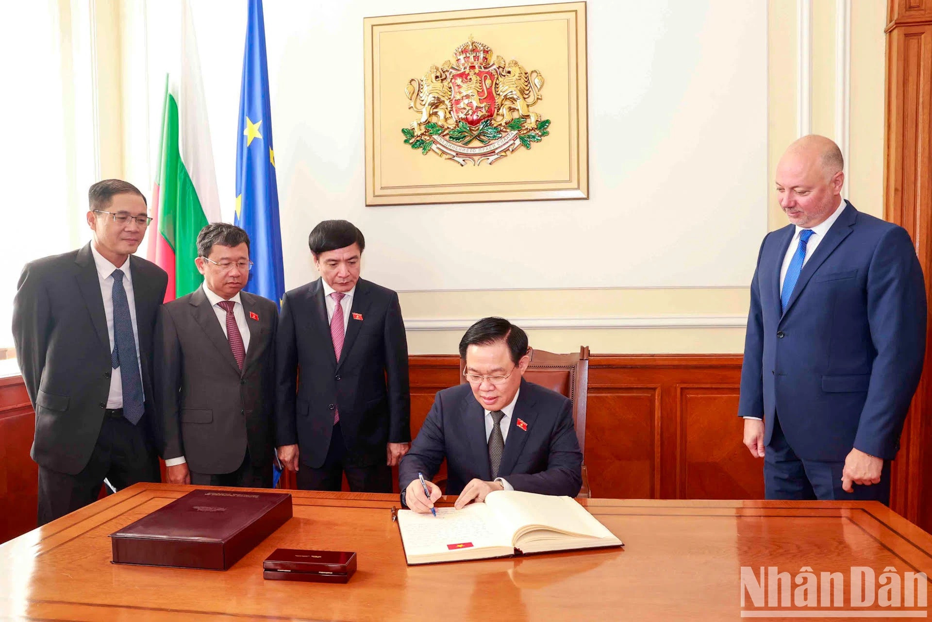 Vuong Dinh Hue firma el libro de visitas en la Asamblea Nacional de Bulgaria.