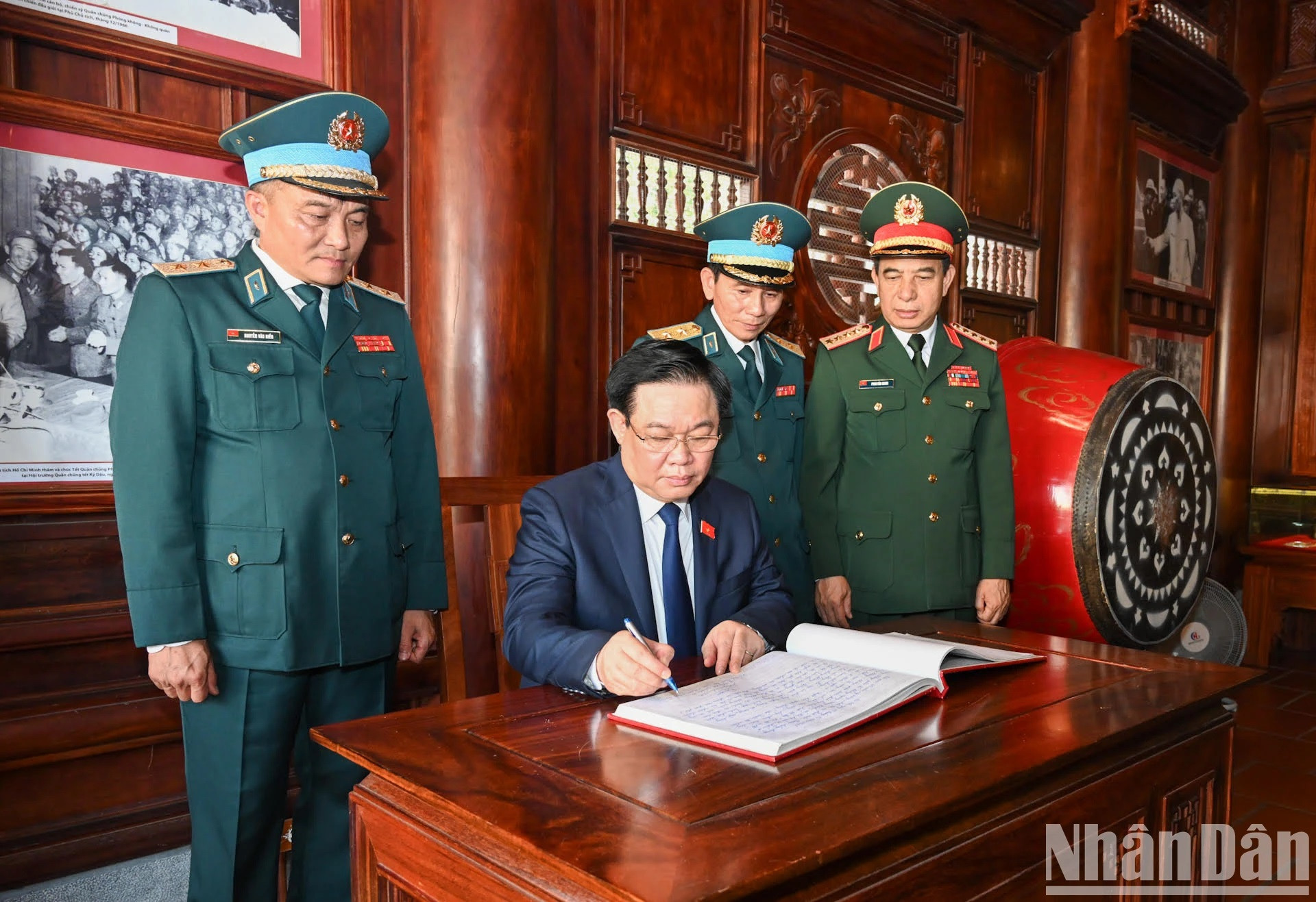 Vuong Dinh Hue escribre en el libro de recuerdo de la Fuerza de Defensa Aérea-Antiaérea.