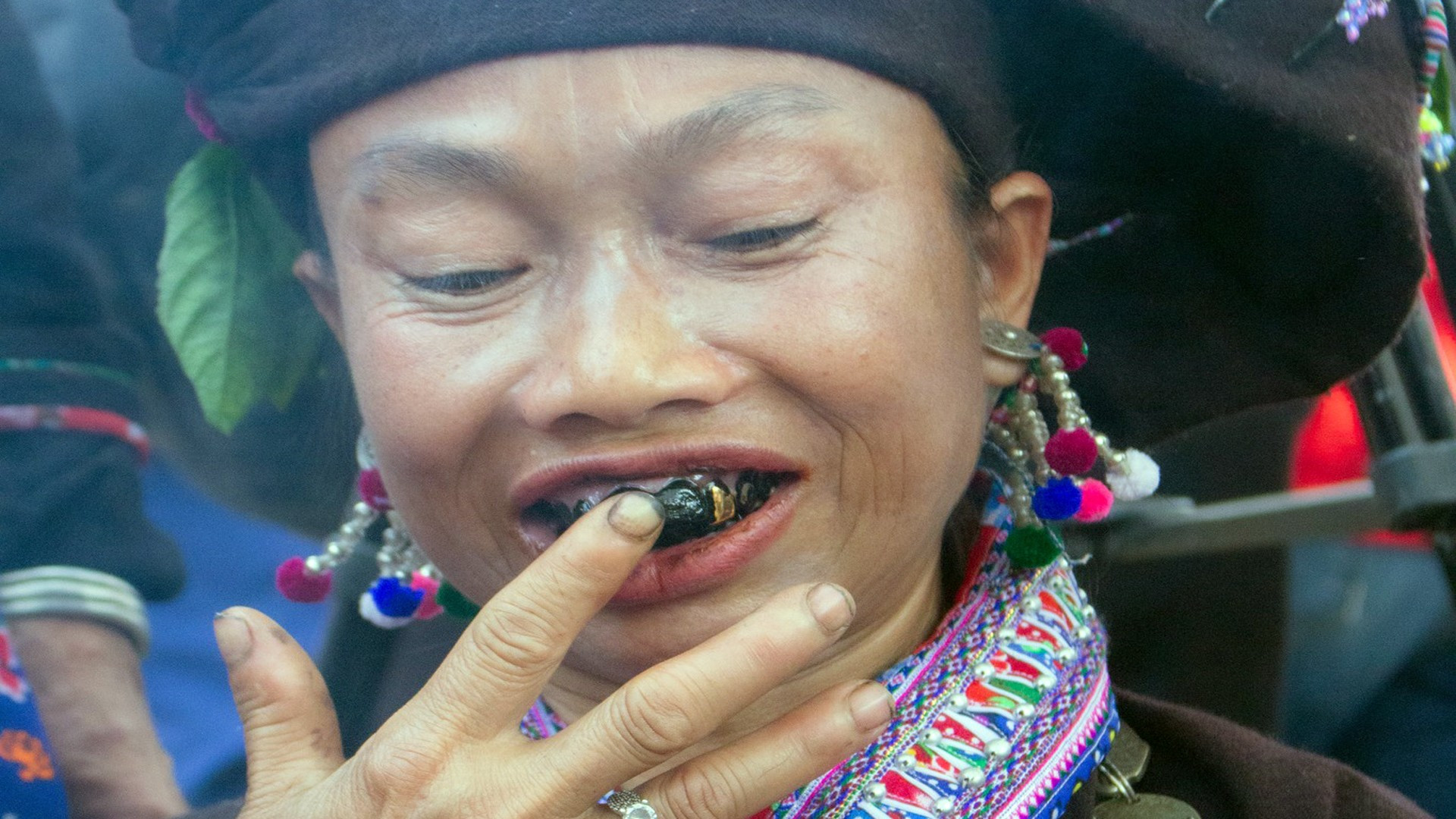 Demostración del proceso de teñir los dientes de negro por mujeres Lao.