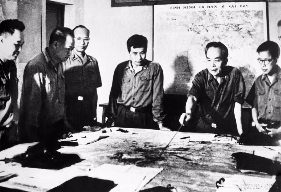 El 14 de abril de 1975, el Buró Político decidió nombrar la campaña de liberación de Saigón-Gia Dinh como la Campaña Ho Chi Minh, con el lema “Velocidad fulminante, audacia, sorpresa y victoria segura”. En la imagen: el General de Ejército Vo Nguyen Giap y los compañeros de la Comisión Militar Central revisan el plan de combate para la Campaña Ho Chi Minh (abril de 1975).