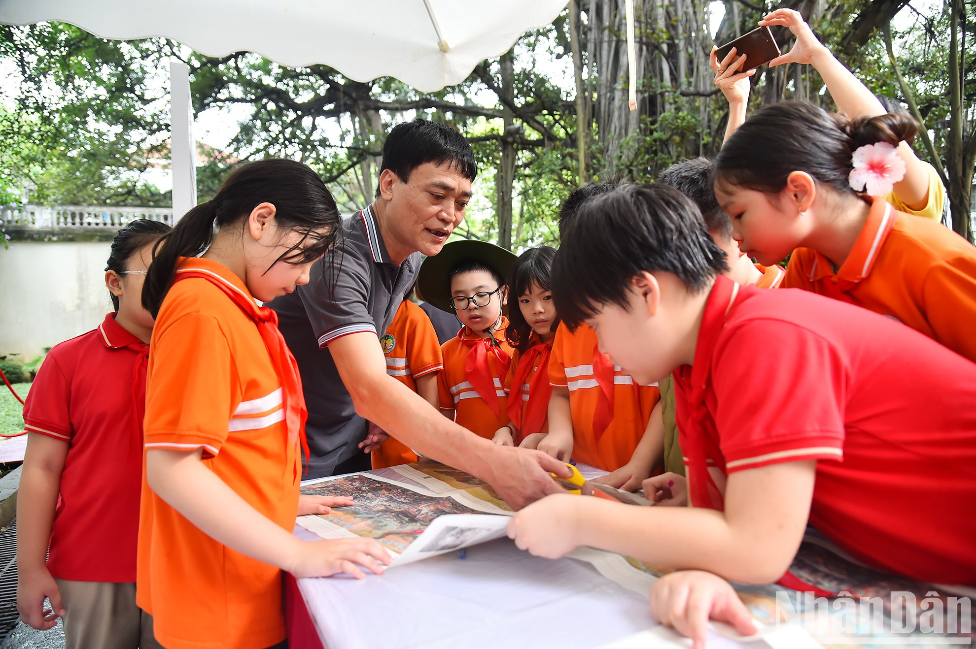 Los alumnos cortan y ensamblan la versión en papel de la pintura panorámica.