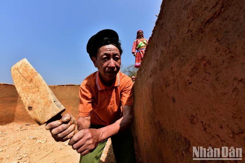 Si Hung daba meticulosamente los toques finales a los muros para garantizar su durabilidad.