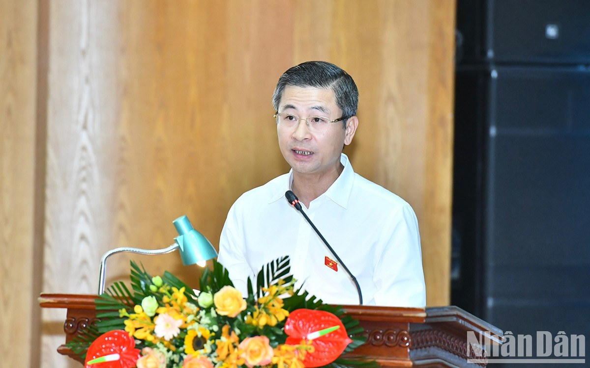 El diputado Nguyen Phi Thuong lee un informe de respuesta a opiniones aportadas por los votantes.