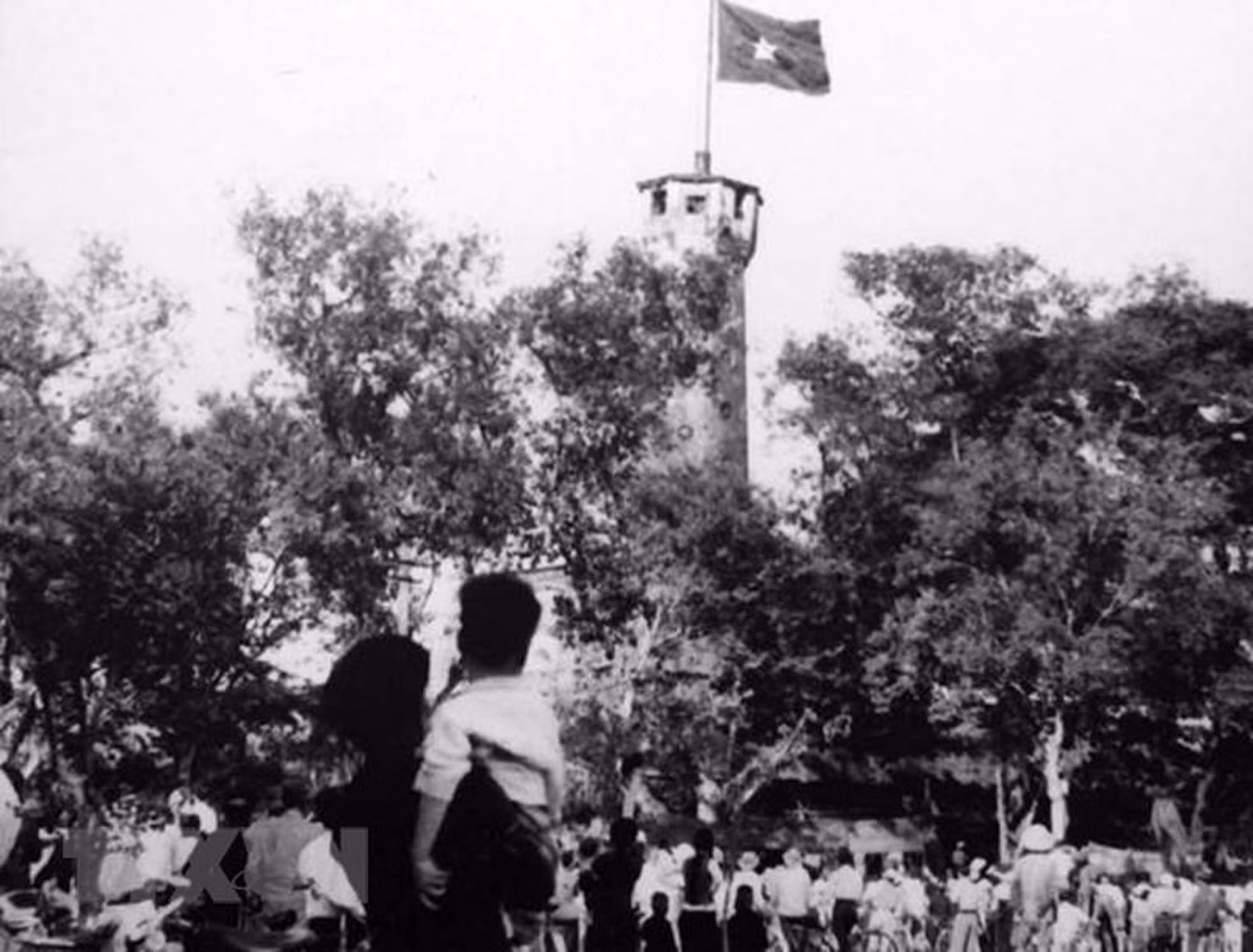 Los capitalinos dirigen sus miradas a la bandera nacional, que ondea en la torre de la bandera de Hanói, el 10 de octubre de 1954.