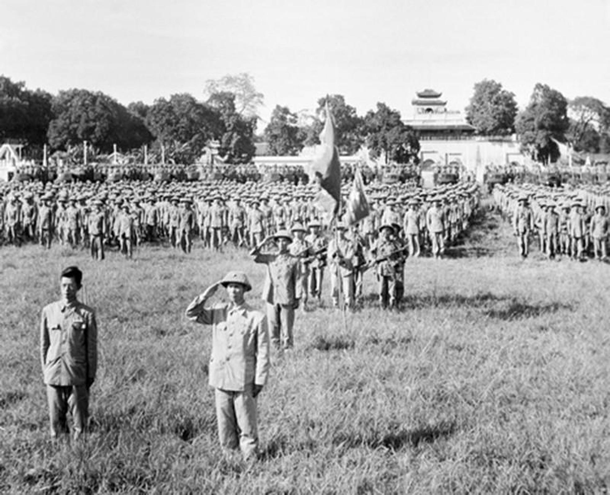 El mayor general Vuong Thua Vu (derecha), comandante de la División 308 y presidente de la Comisión Militar de Hanói, y el doctor Tran Duy Hung (izquierda), vicepresidente de la misma, junto con las unidades dependientes de la División 308 encargadas de tomar el control de Hanói, en la ceremonia de saludo a la bandera nacional en el Día de la Liberación de la Capital, efectuada en la torre de la bandera (hoy Doan Mon, puerta principal) de la Ciudadela Imperial de Thang Long, a las 3:00 pm del 10 de octubre de 1954.