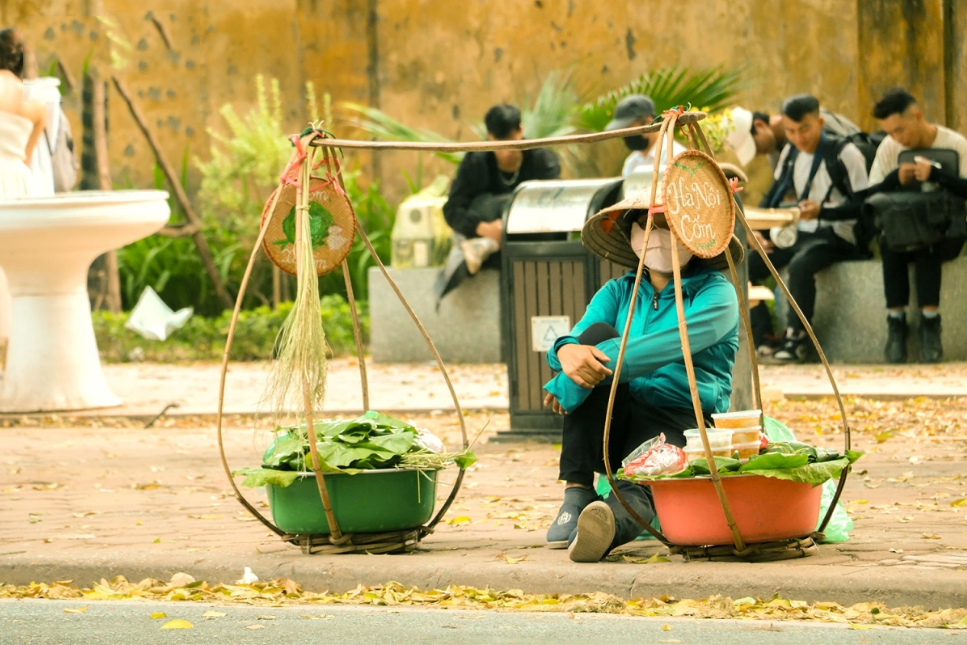 Nguyen Thi Chieu, natural de la provincia de Phu Tho, lleva más de 20 años vendiendo "com" en la capital. Según ella, los hanoyenses buscan esa delicia sencilla cada vez que llega el otoño.