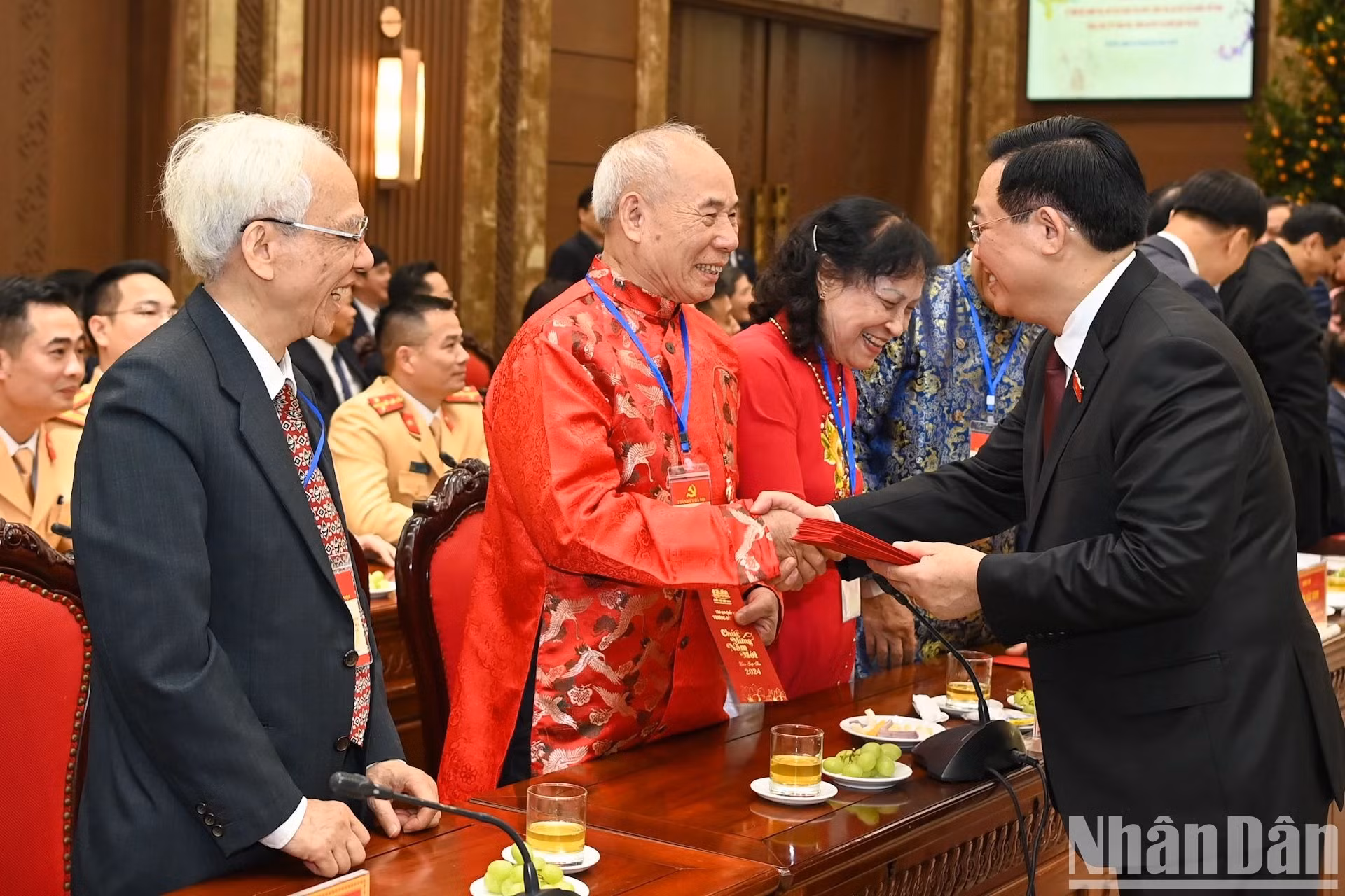 Dinh Hue ofrece dinero de suerte a los ancianos participantes.