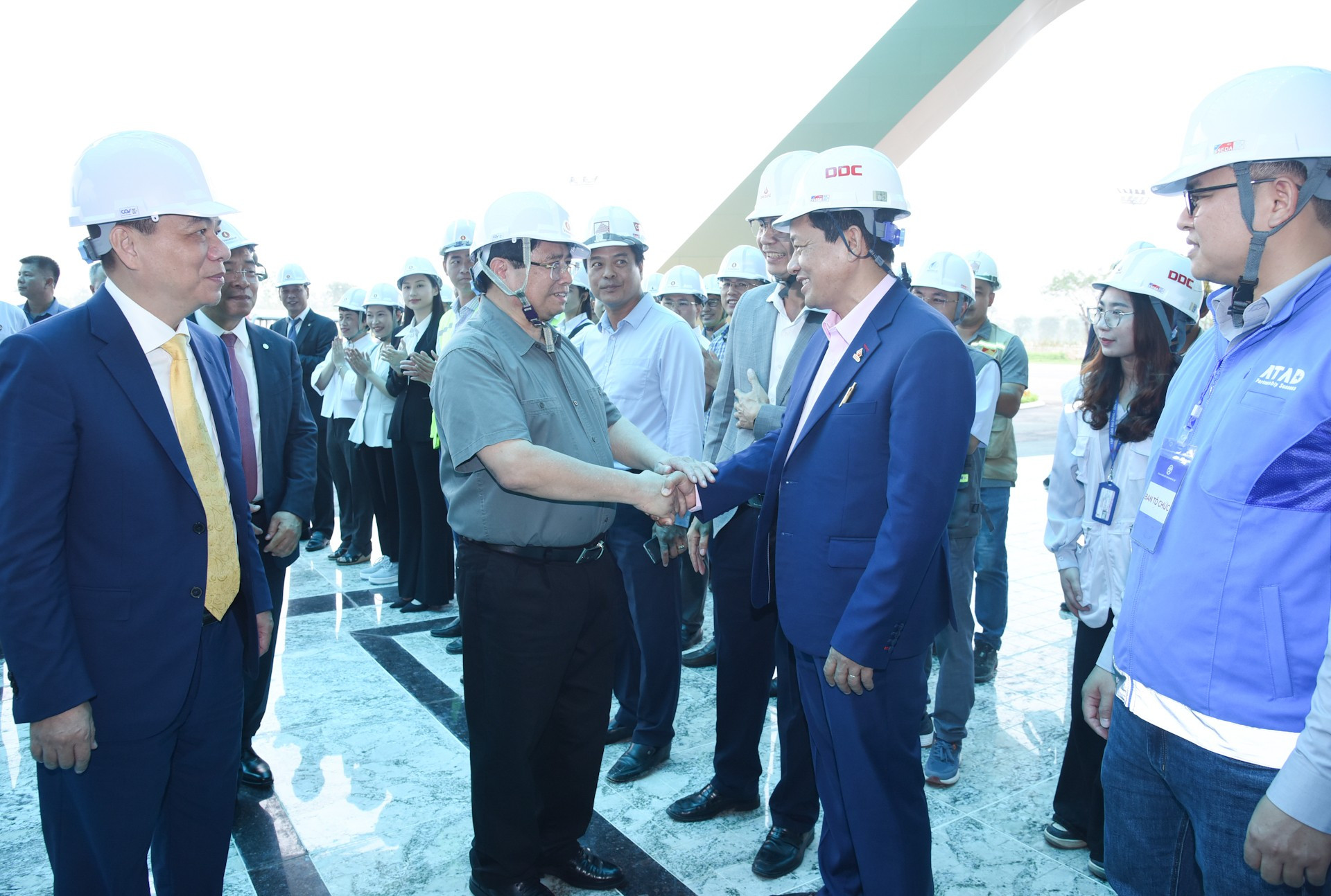 Minh Chinh conversa con ingenieros y obreros. Minh Chinh conversa con ingenieros y obreros.