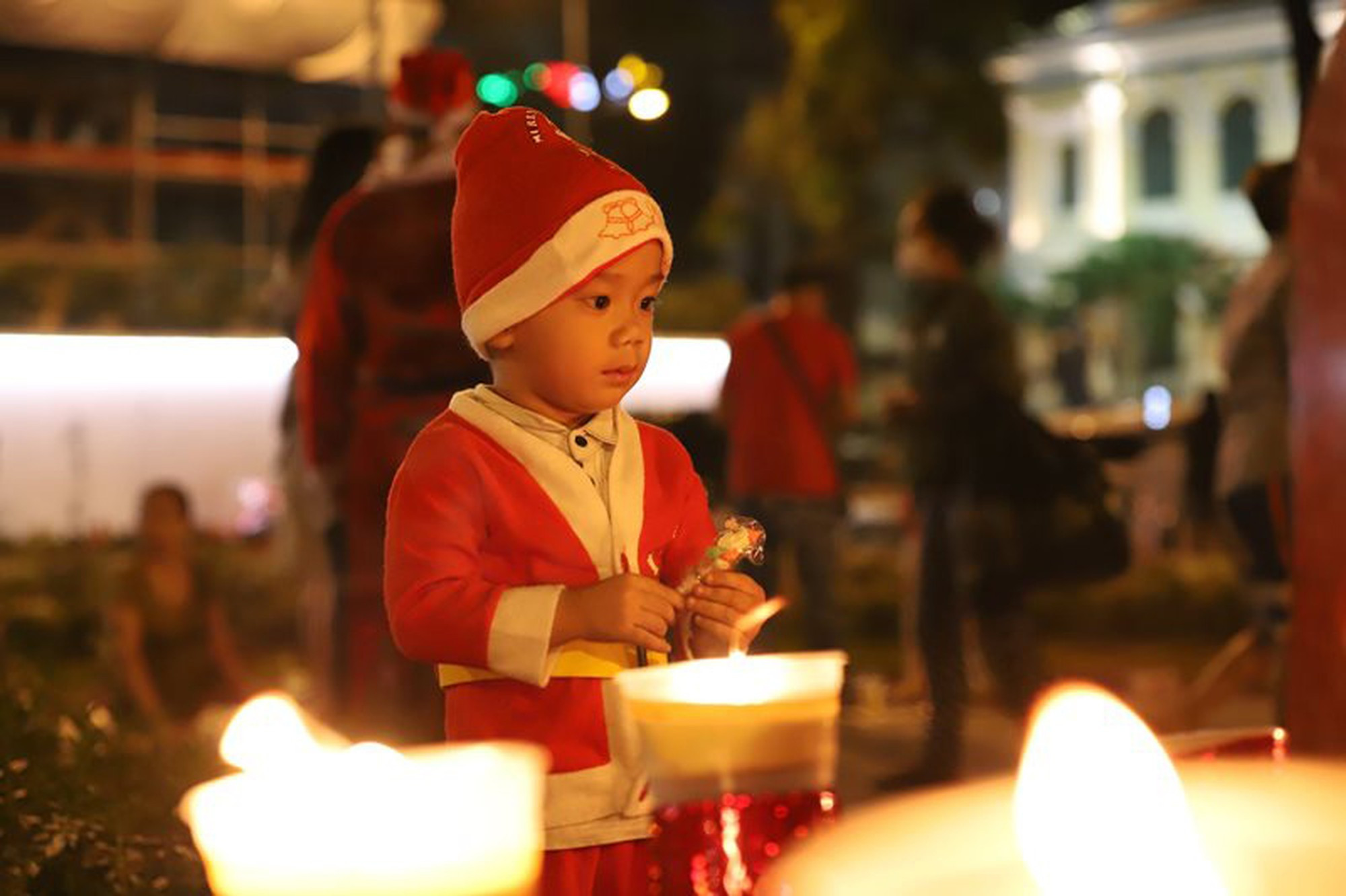 Un niño disfrazado de Papá Noel reza ante la estatua de Nuestra Señora de la Paz colocada en el patio de la mencionada catedral.