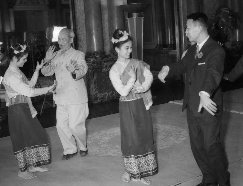 El Presidente Ho Chi Minh y el Rey de Laos, Xavang Vatthana, bailan y cantan con actores en Hanói, con motivo de una visita a la fábrica mecánica de Hanói (12 de marzo de 1963).