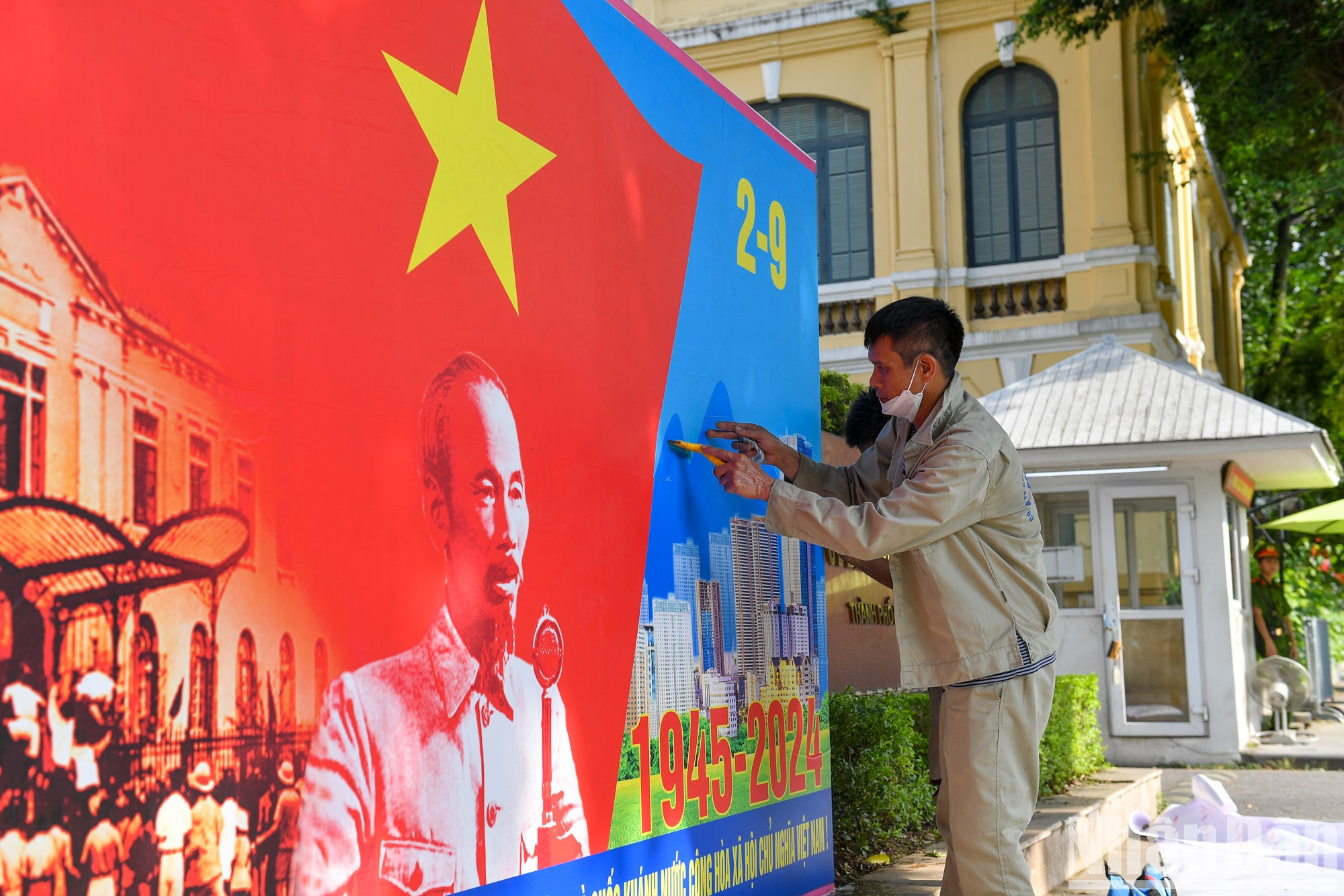 Un trabajador coloca un cartel al frente de la sede del Comité Popular municipal.