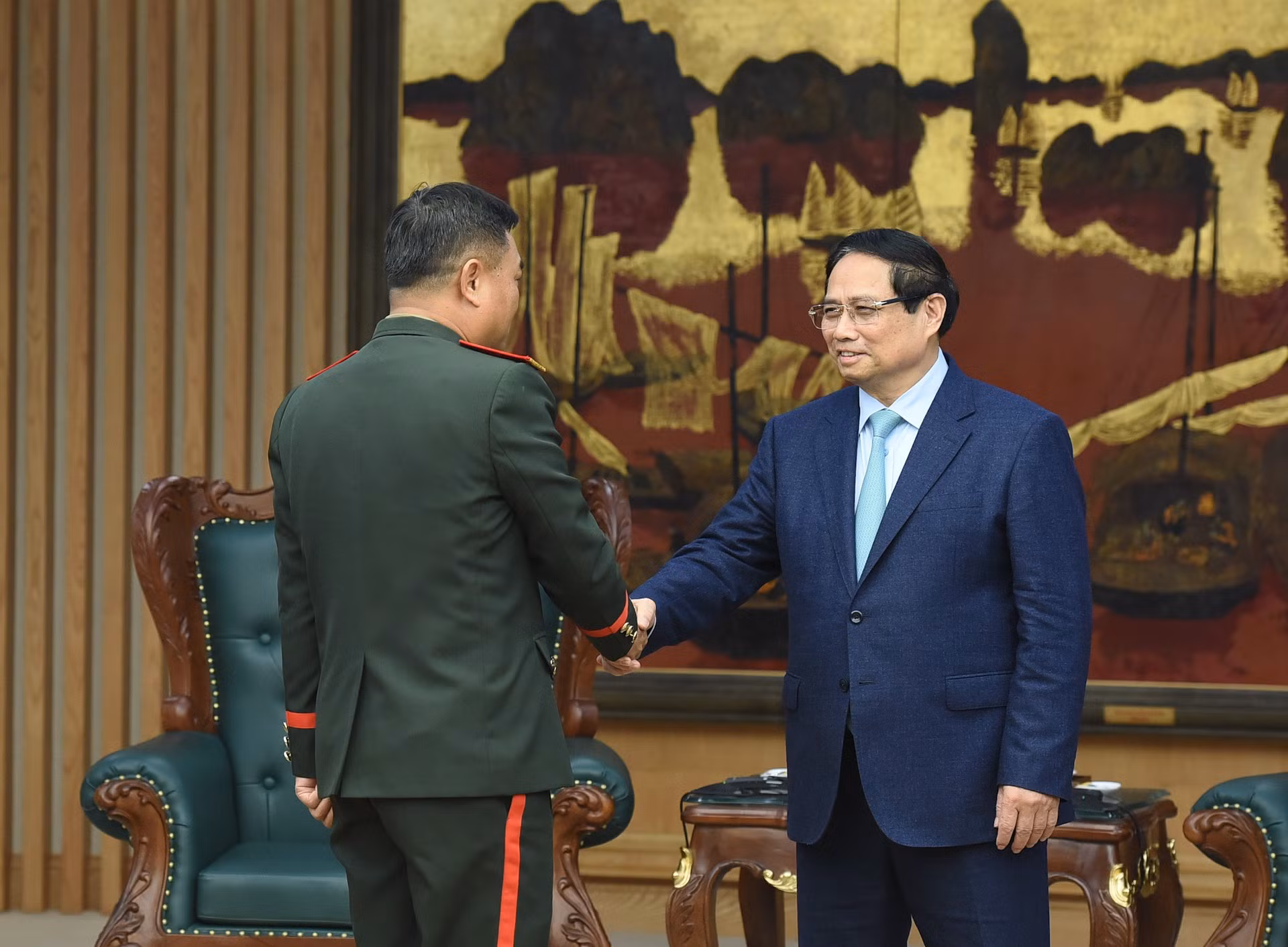 El primer ministro Pham Minh Chinh recibe al teniente general Saichay Kommasith, viceministro de Defensa y jefe del Estado Mayor General del Ejército Popular de Laos.