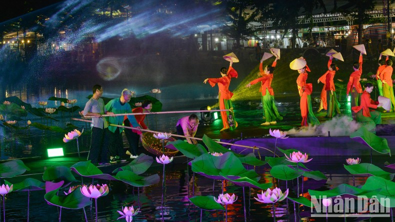 Los espectadores en la inauguración disfrutan del espectáculo semirealista “Historia de Loto”, interpretado en un escenario sobre agua. Los espectadores en la inauguración disfrutan del espectáculo semirealista “Historia de Loto”, interpretado en un escenario sobre agua.