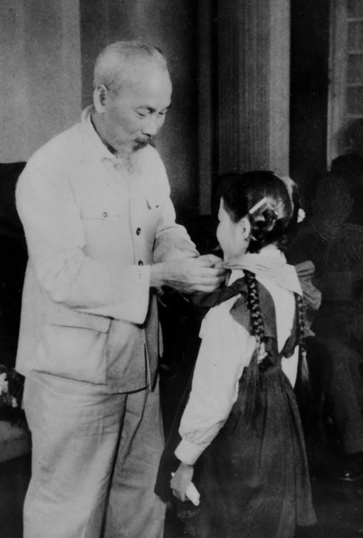 El Presidente Ho Chi Minh colocando la bufanda roja a los niños delegados de Hanói en 1960.