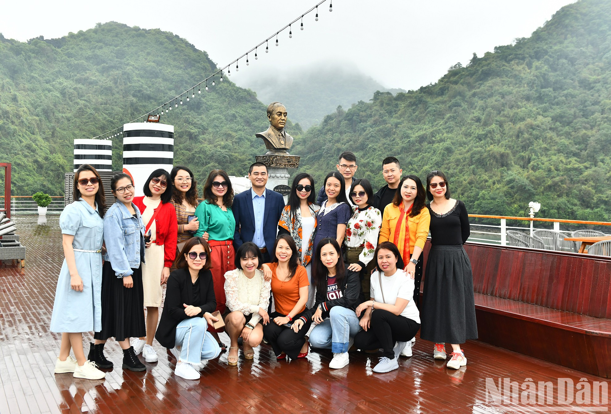 Los turistas posan teniendo como fondo una estatua de Bach Thai Buoi.