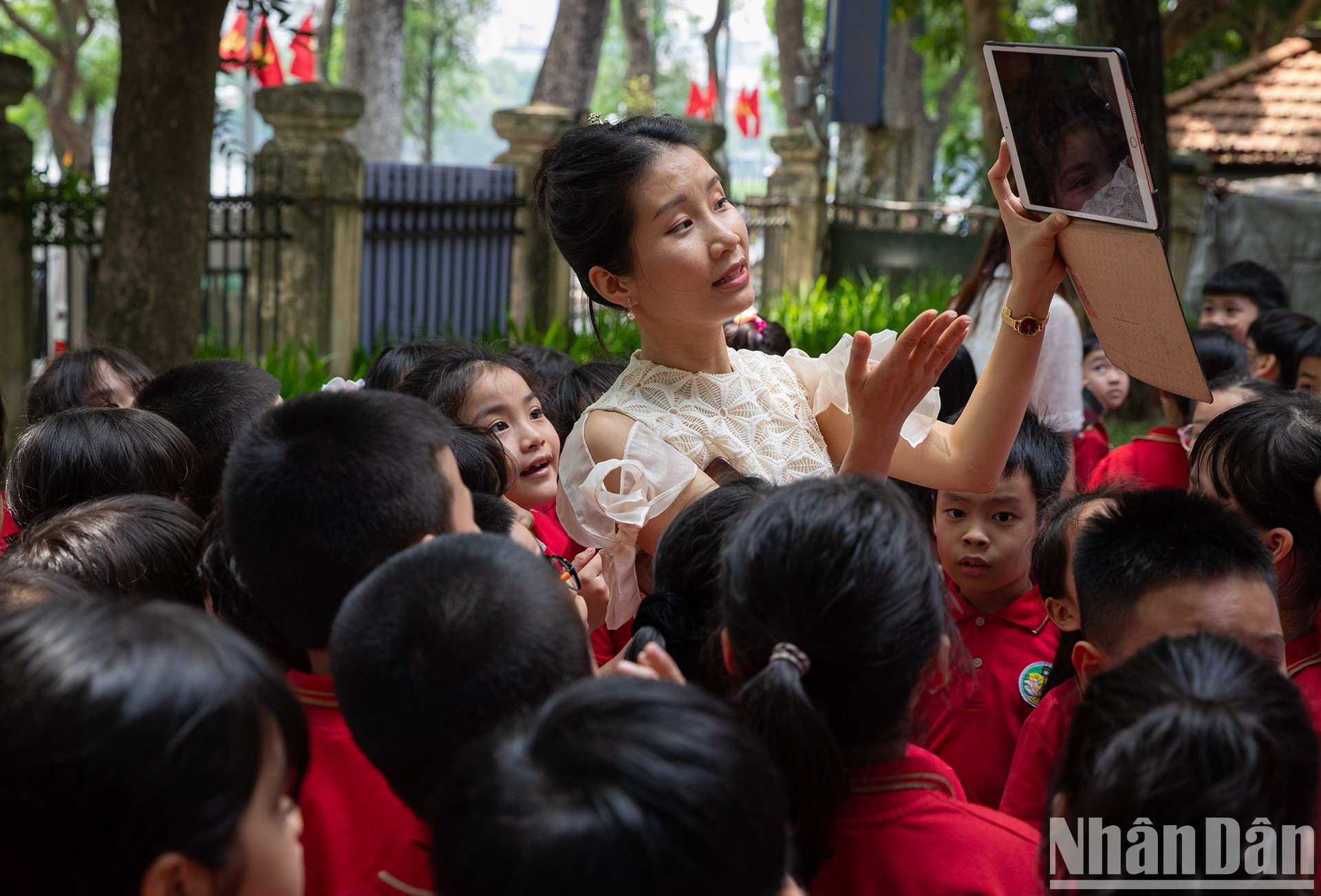 Una miembro de la Unión de Jóvenes Ho Chi Minh en Nhan Dan sirve de guía a los pequeños visitantes. Una miembro de la Unión de Jóvenes Ho Chi Minh en Nhan Dan sirve de guía a los pequeños visitantes.