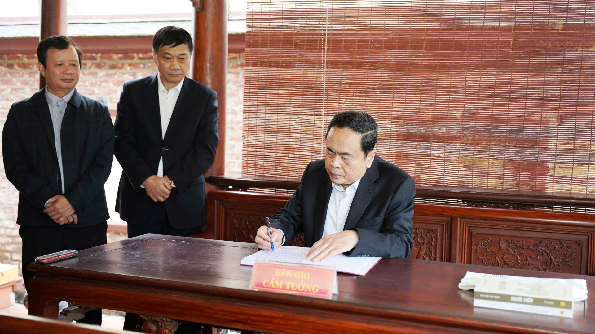 El dirigente escribe en el libro de visitas del museo.