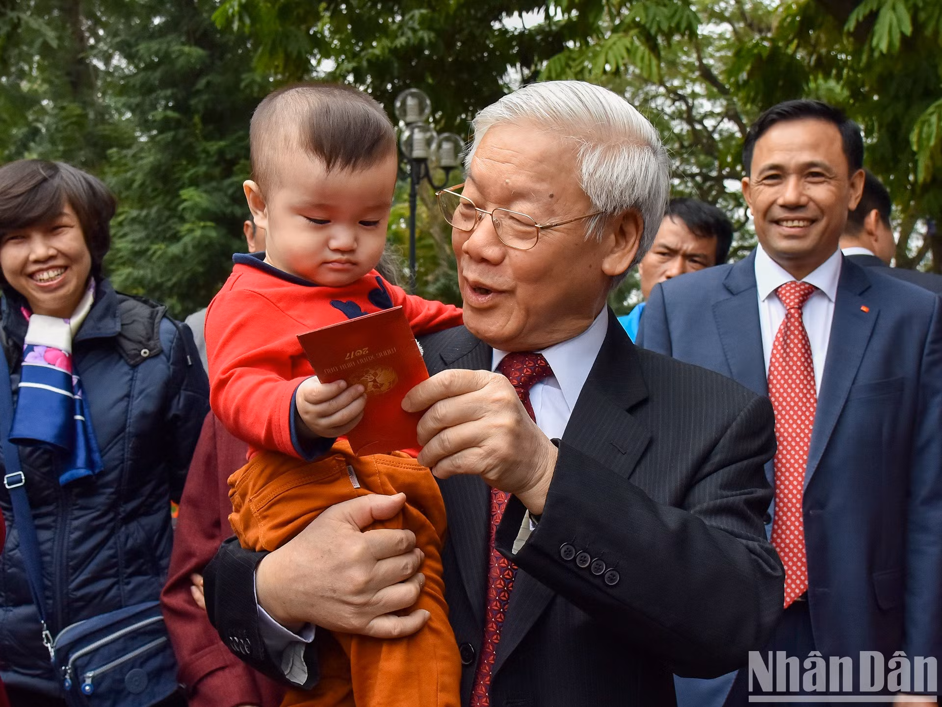 El secretario general Nguyen Phu Trong regala dinero de suerte a un niño.