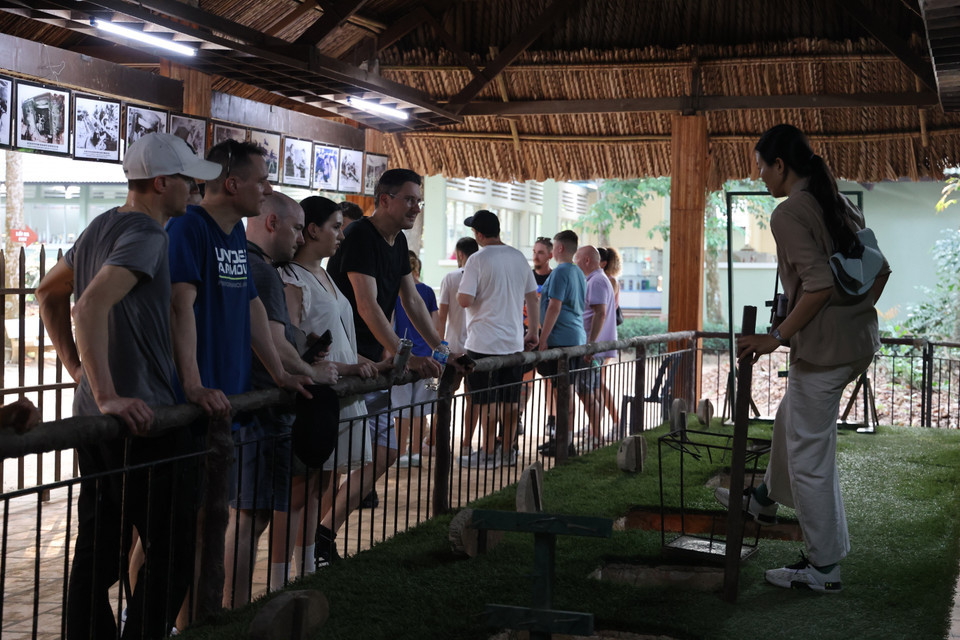 Visitantes extranjeros escuchan atentamente la explicación del guía sobre la utilidad de las trampas en combate.