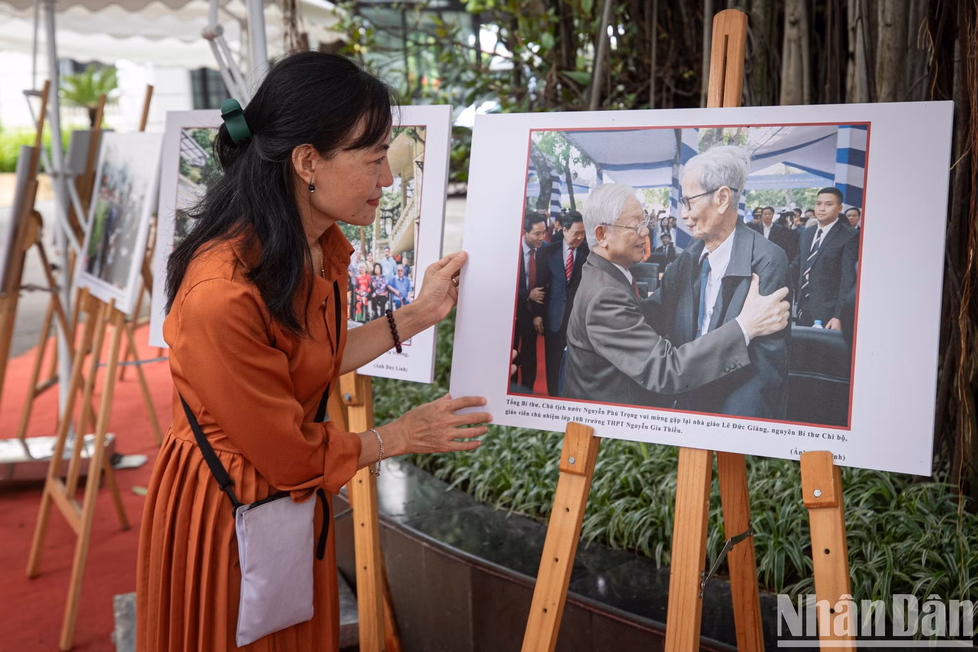 Khuong Thuy, empleada de la Voz de Vietnam, observa una foto del secretario general Nguyen Phu Trong y del periodista Le Duc Giang tomada por un periodista de Nhan Dan.