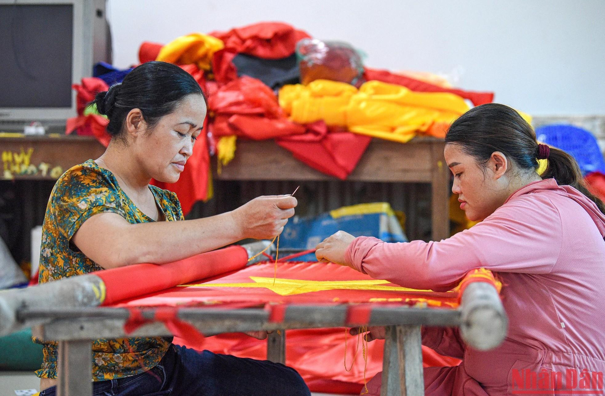 La familia de Vuong Thi Nhung se dedica a la confección de la bandera nacional desde que existió el oficio. Ella en particular es conocida por sus habilidades de bordar a mano estrellas doradas de cinco puntas.