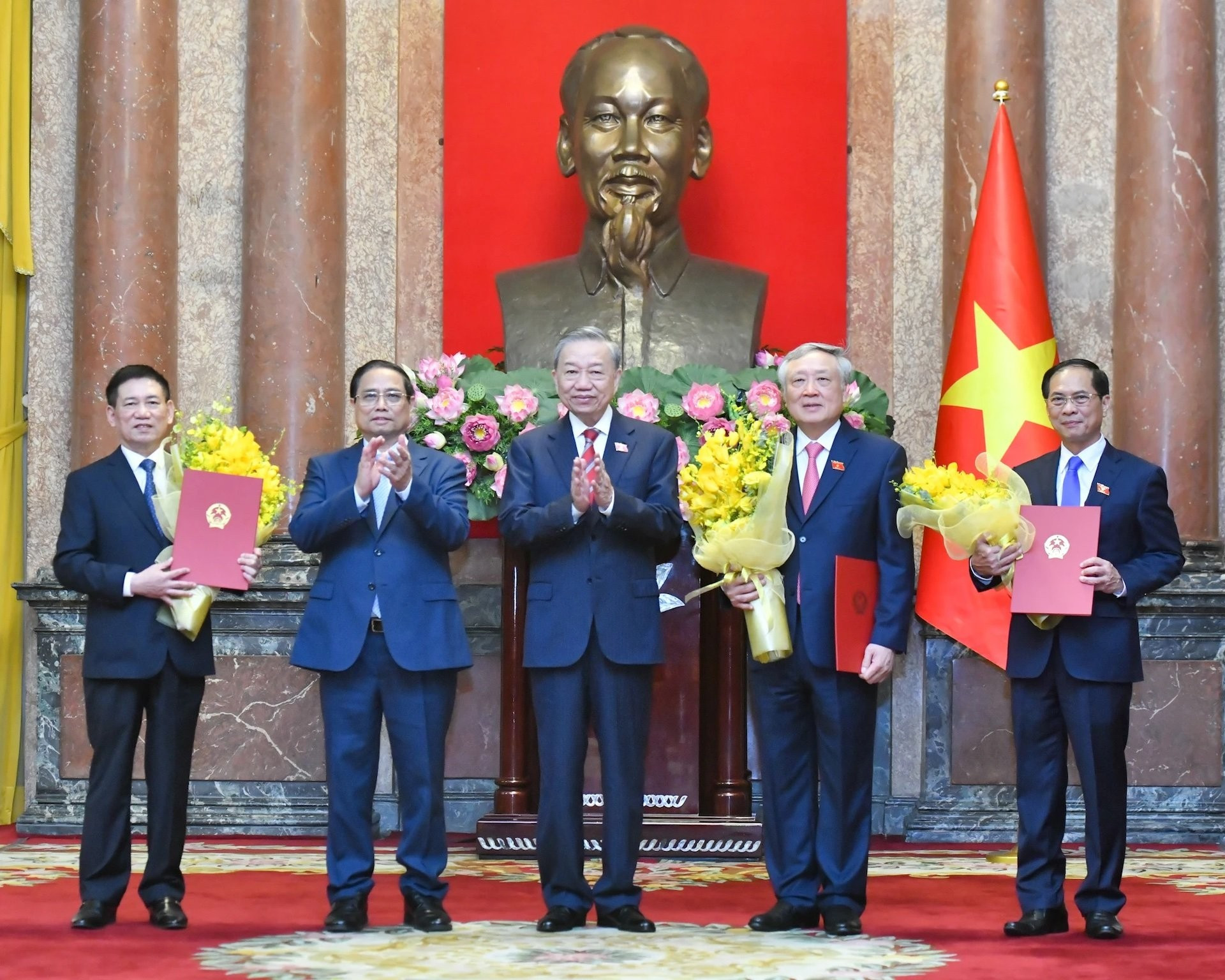 El secretario general del PCV y presidente To Lam entrega las decisiones y el premier Pham Minh Chinh flores de felicitación a los nuevos subjefes de Gobierno.