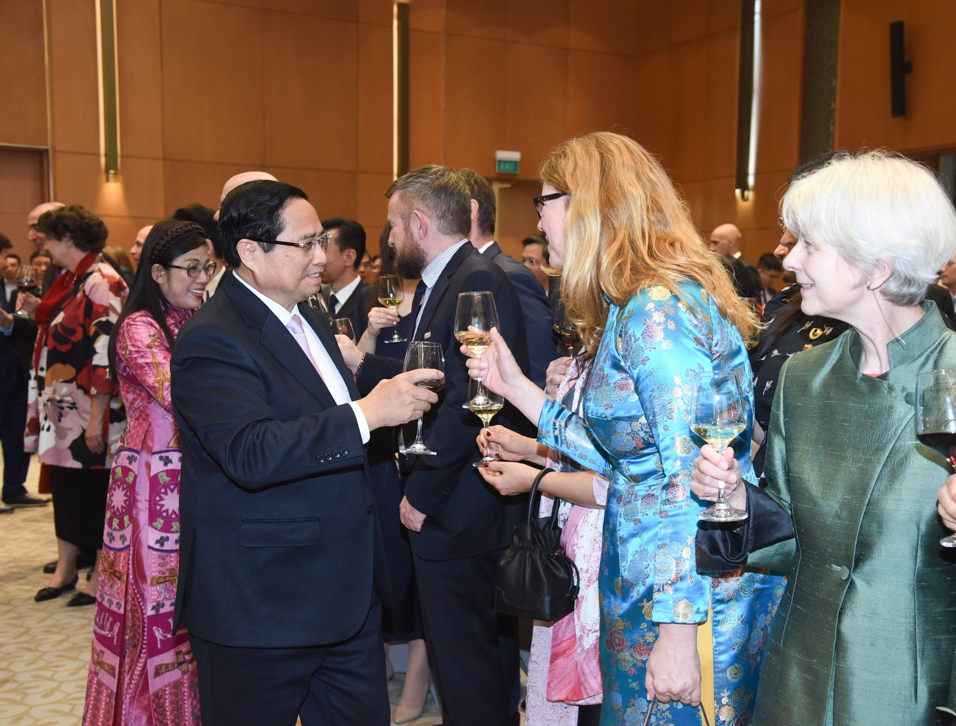 El dirigente vietnamita y su esposa saludan a los diplomáticos.
