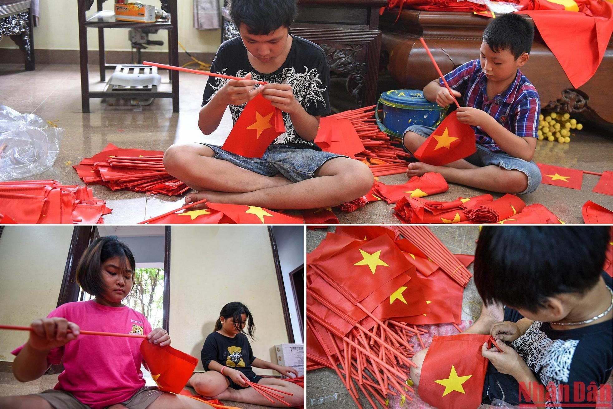 Niños elaborando banderas nacionales de mano, el tipo que suelen sostener los alumnos en el acto de inicio de un nuevo año escolar.