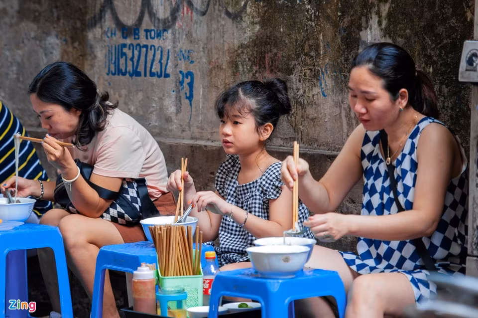 En el cercano callejón de Au Trieu, mucha gente acude al lugar titulado “Tư Lùn” desde temprano para desayunar. Durante la hora punta (7:00-9:00), incluso se ve a personas comiendo su porción sobre taburetes dispuestos al aire libre o en la cafetería del lado.