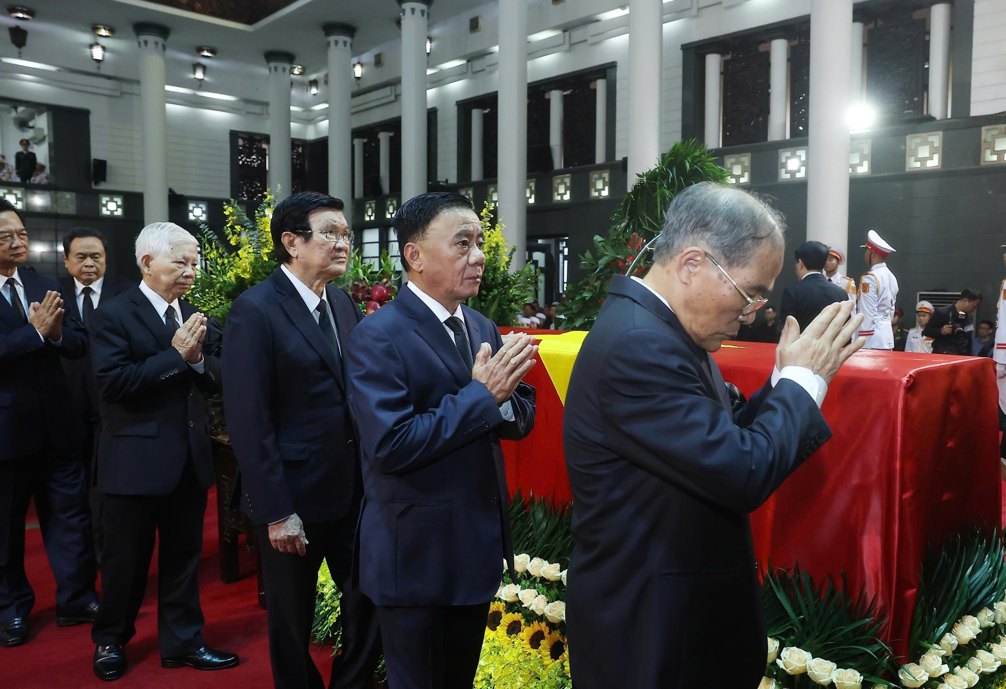 Los miembros de la delegación rinden tributo al extinto.