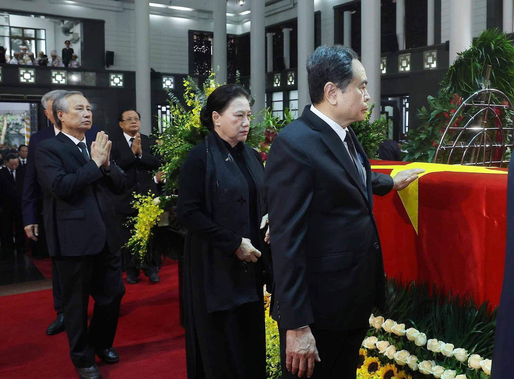 Los miembros de la delegación rinden tributo al extinto.