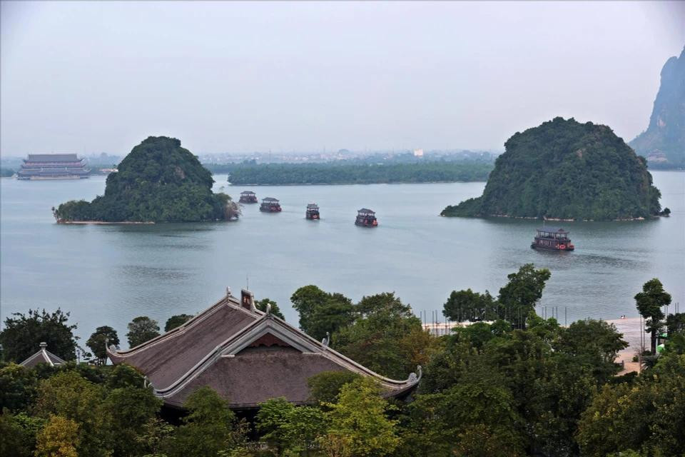 Los barcos pequeños se deslizan suavemente sobre el agua, creando un entorno poético al acercarse al complejo de la pagoda.