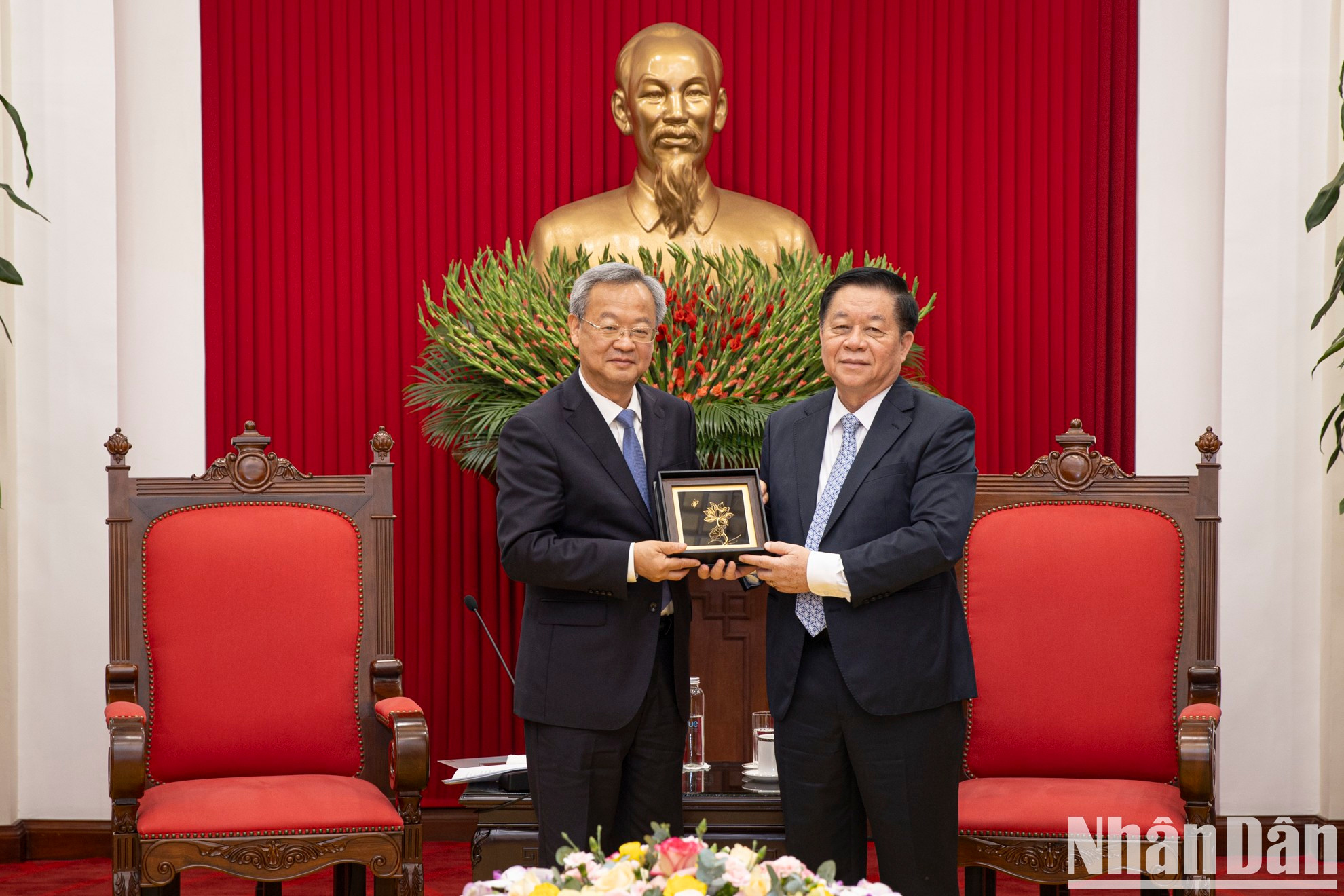 El funcionario del PCV entrega un regalo de recuerdo al visitante chino.