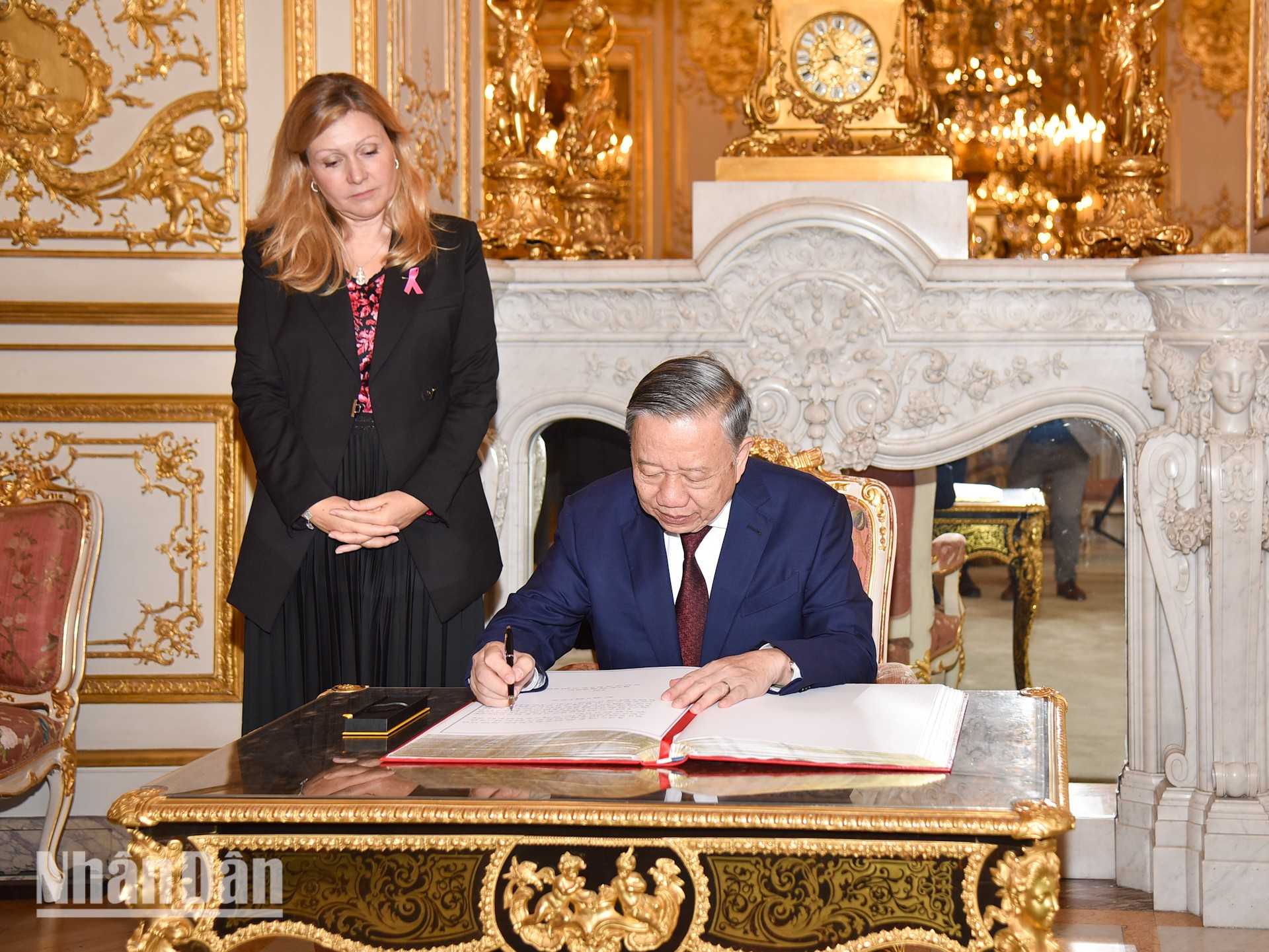 El máximo dirigente vietnamita escribe en el libro de recuerdos en la sede de la Asamblea Nacional francesa.
