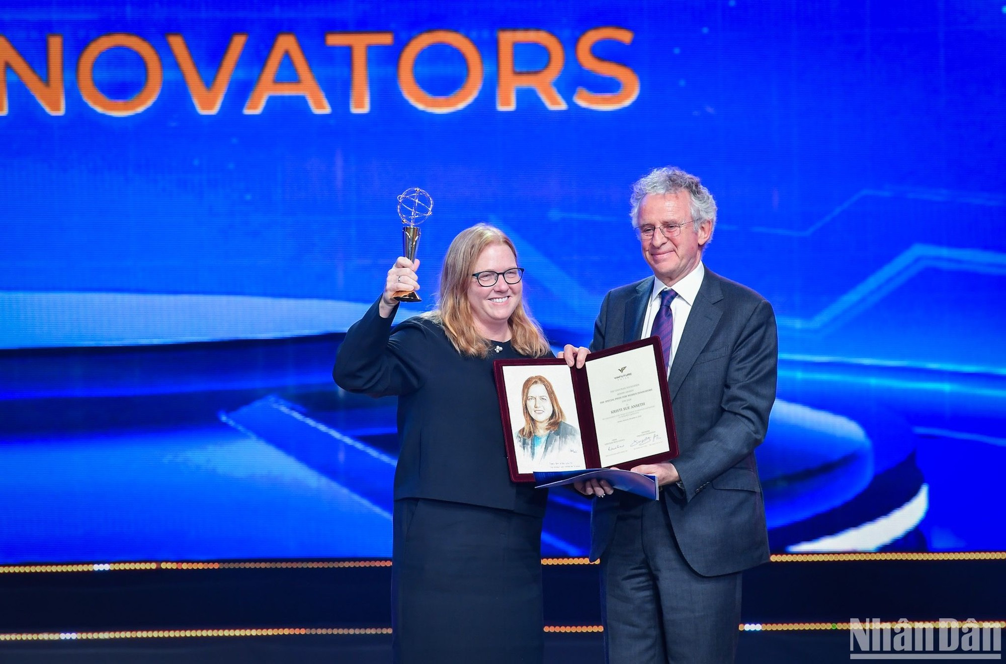 El profesor Richard Henry Friend, presidente del Consejo de los Premios de VinFuture, entrega el trofeo y el certificado a la profesora Kristi S. Anseth, ganadora del Premio Especial para Mujeres Científicas por lograr avances en el diseño de materiales poliméricos y métodos para aplicaciones biomédicas.