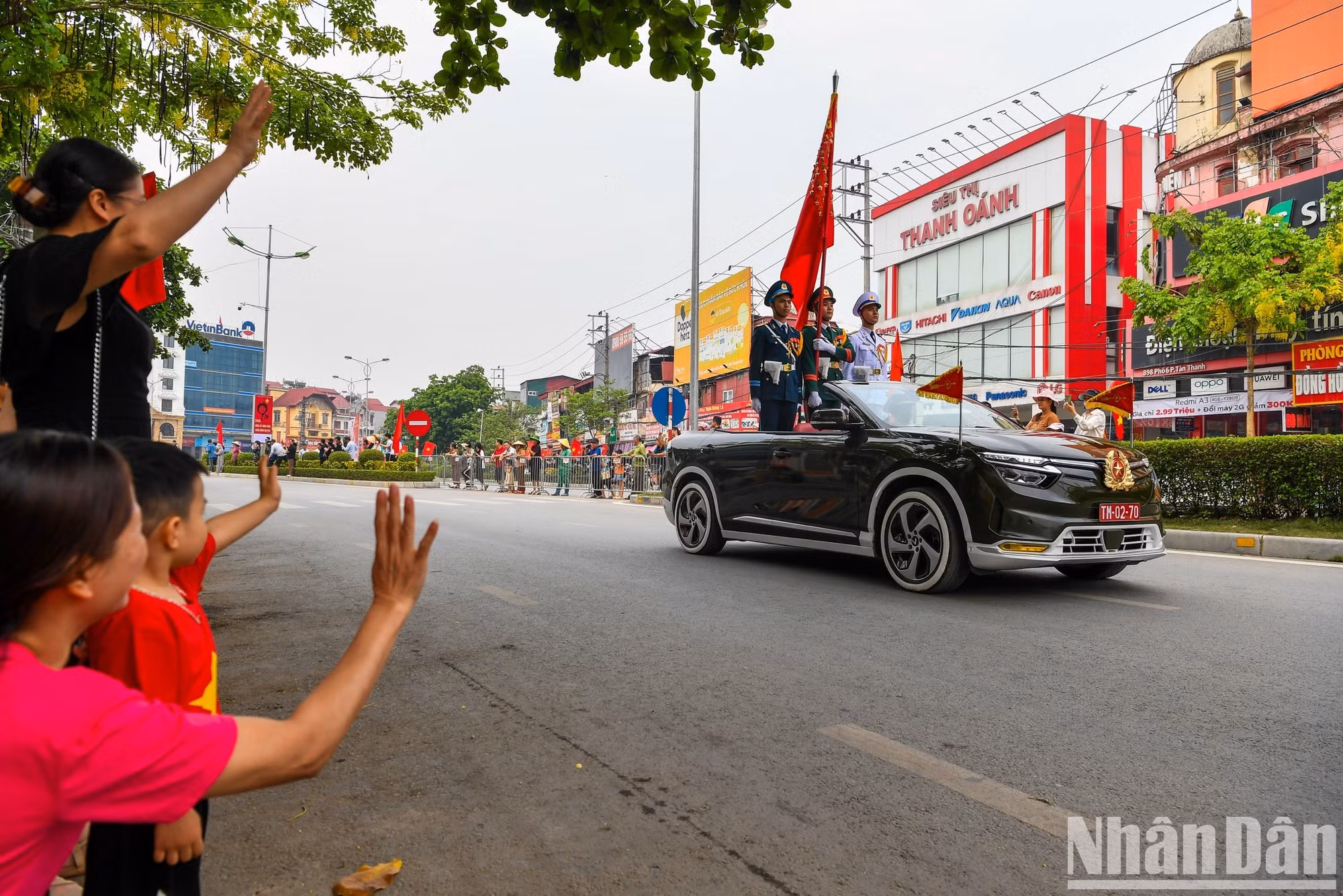 Residentes y visitantes saludan a las tropas participantes en el desfile.