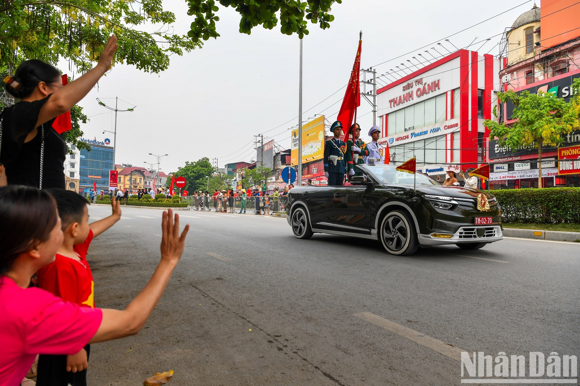 Residentes y visitantes saludan a las tropas participantes en el desfile.