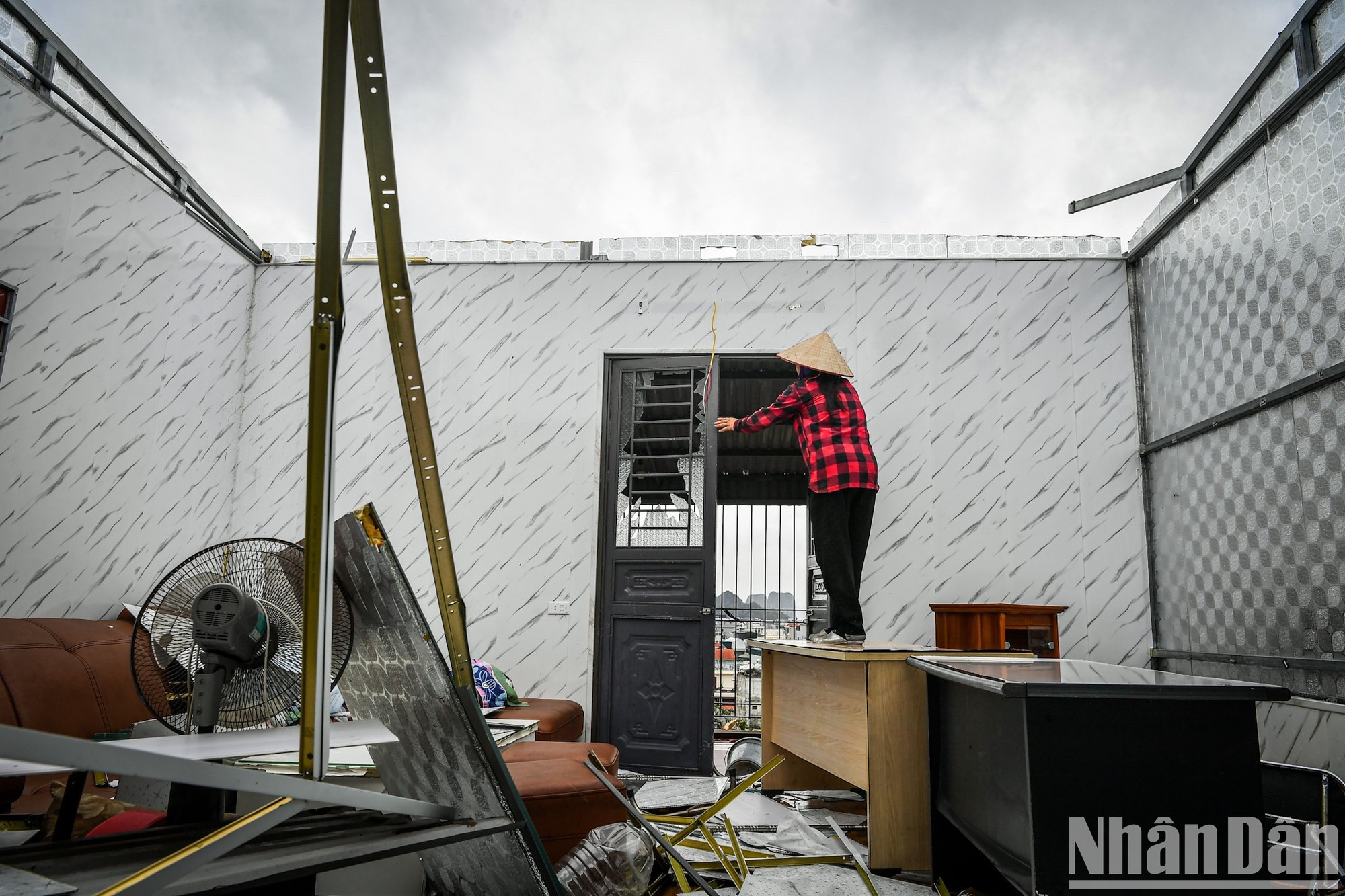 Un residente del distrito de Hong Hai, cuyo tejado se voló durante la noche de la supertormenta, limpia la casa. Un residente del distrito de Hong Hai, cuyo tejado se voló durante la noche de la supertormenta, limpia la casa.