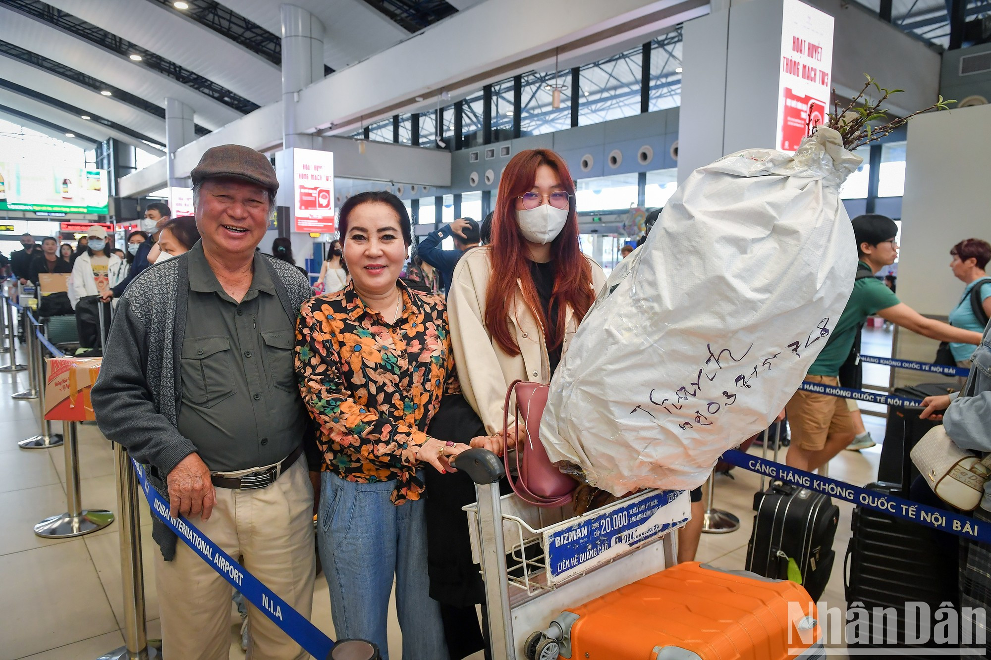Tuan, de 76 años, de Hanói y su familia llevan ramas de melocotón Nhat Tan a Ciudad Ho Chi Minh.