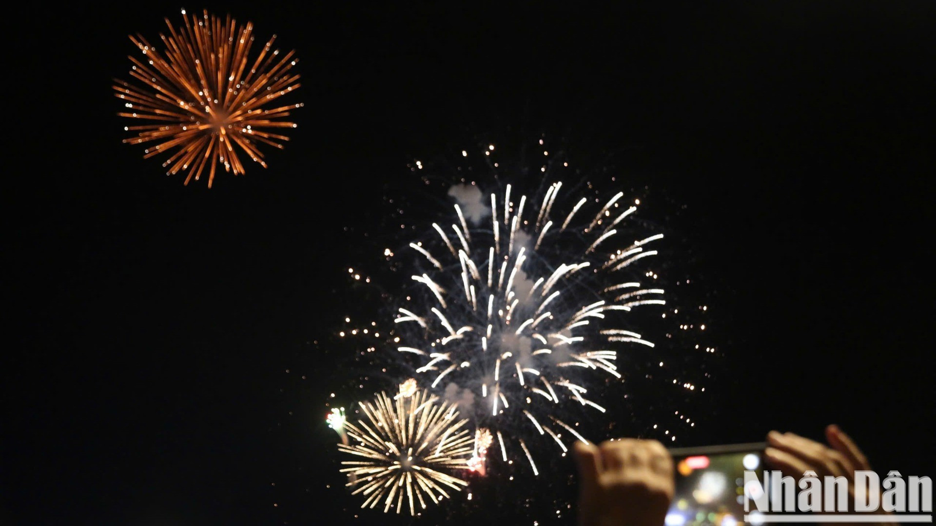 Los habitantes locales capturan el momento en que los fuegos artificiales iluminan el cielo. Los habitantes locales capturan el momento en que los fuegos artificiales iluminan el cielo.