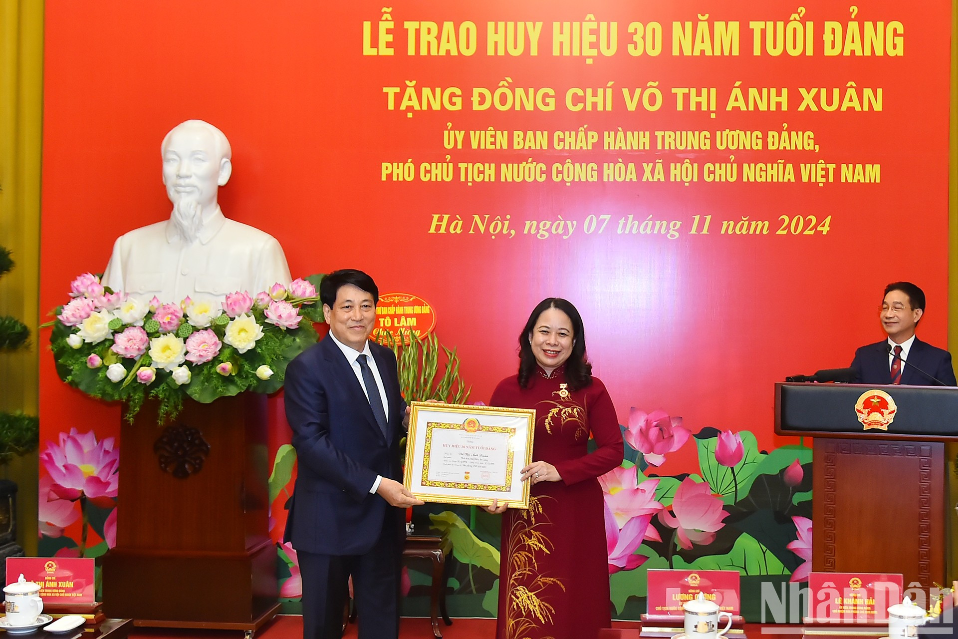 El presidente de Vietnam, Luong Cuong, entrega la insignia por los 30 años de membresía del PCV a la funcionaria vietnamita.