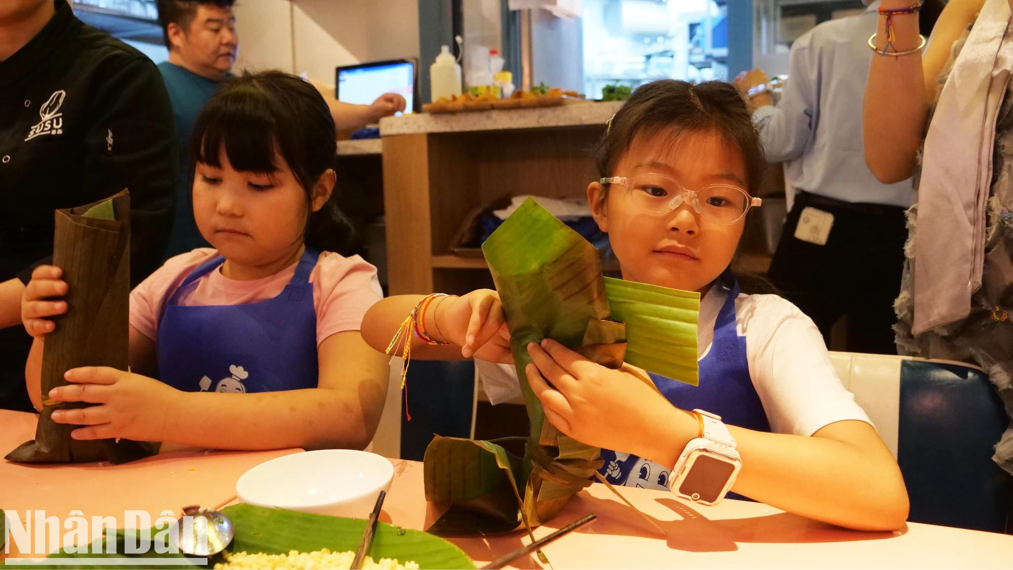 Un niño en Pekín observa y experimenta la elaboración de “banh chung” vietnamita. Un niño en Pekín observa y experimenta la elaboración de “banh chung” vietnamita.
