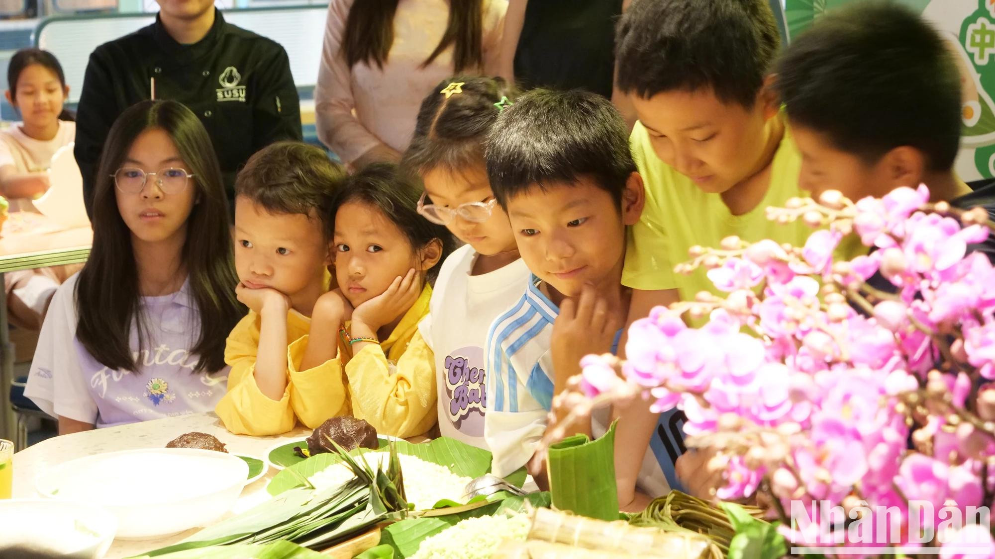 Los niños vietnamitas y chinos experimentan la elaboración de “banh u” y “banh chung”. Los niños vietnamitas y chinos experimentan la elaboración de “banh u” y “banh chung”.
