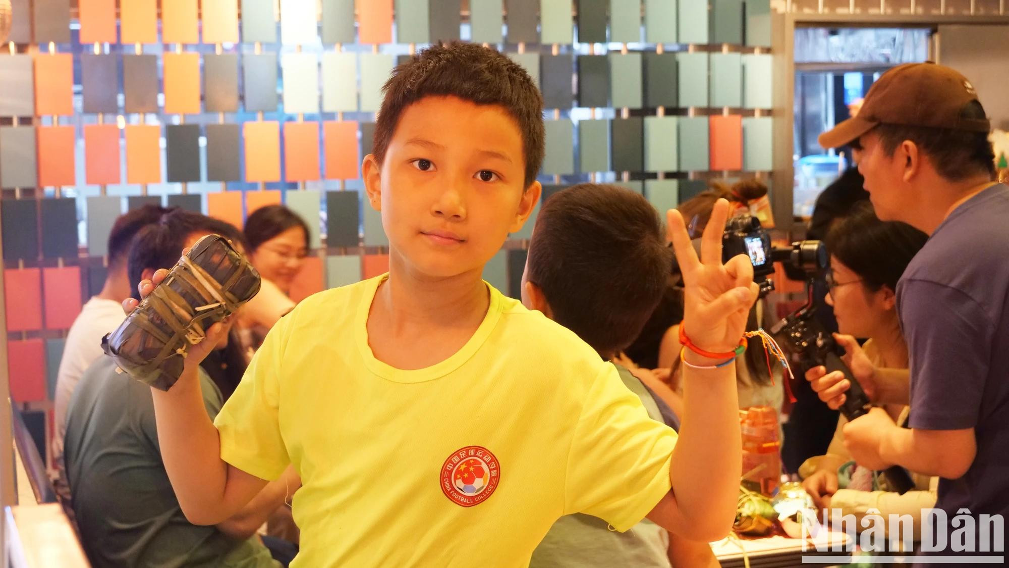 Un adolescente en Pekín presenta su “banh chung”. Un adolescente en Pekín presenta su “banh chung”.