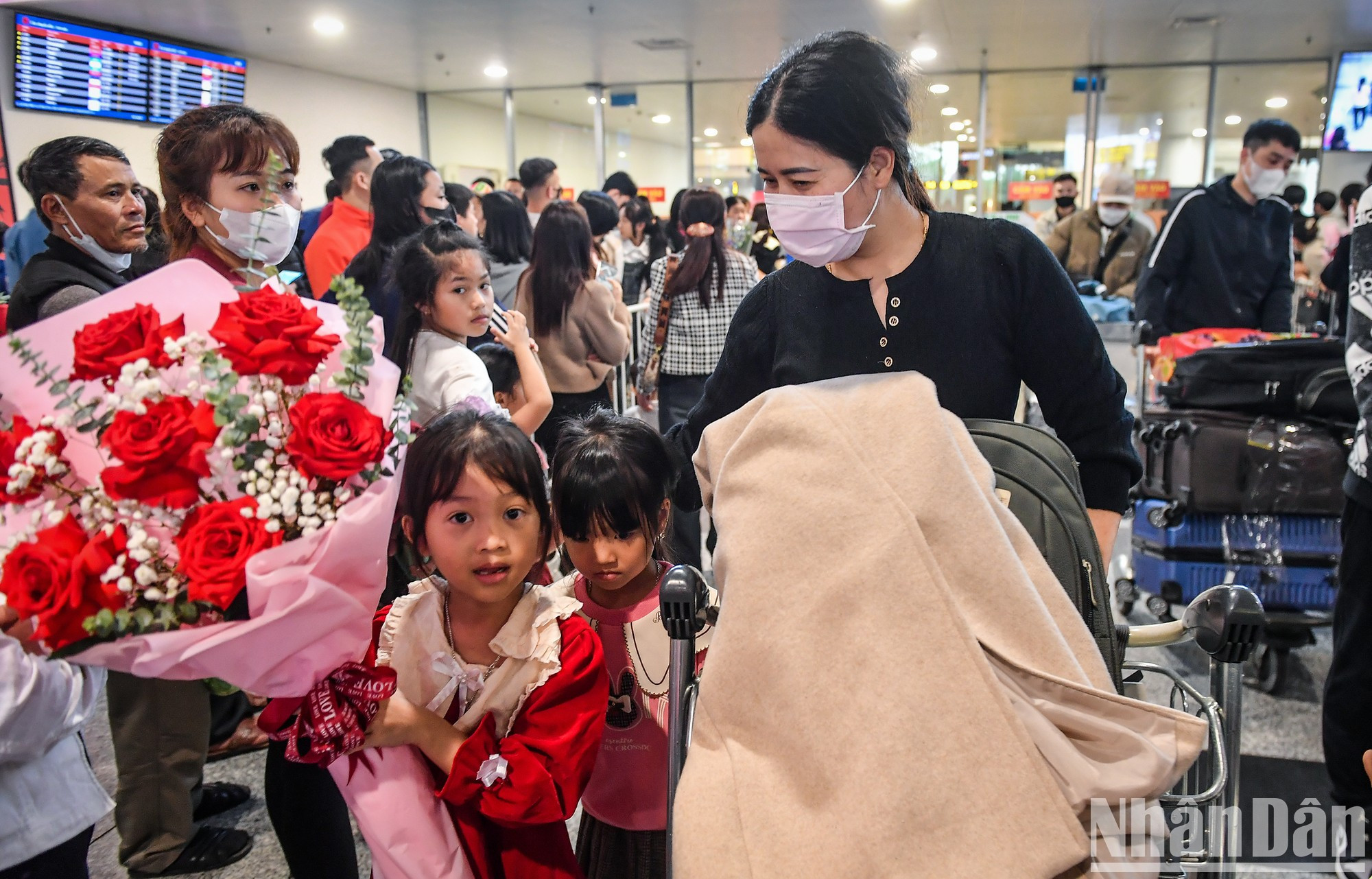 Thuy, de 45 años, regresa de Taiwán (China) y es recibida por sus hijos con un hermoso ramo de flores.