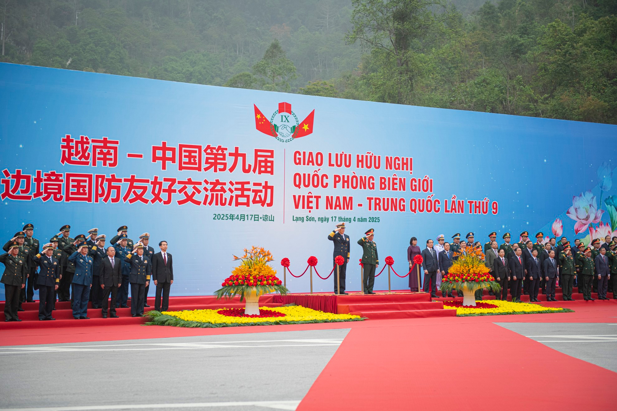 Los dos ministros escuchan los himnos nacionales de sus países.