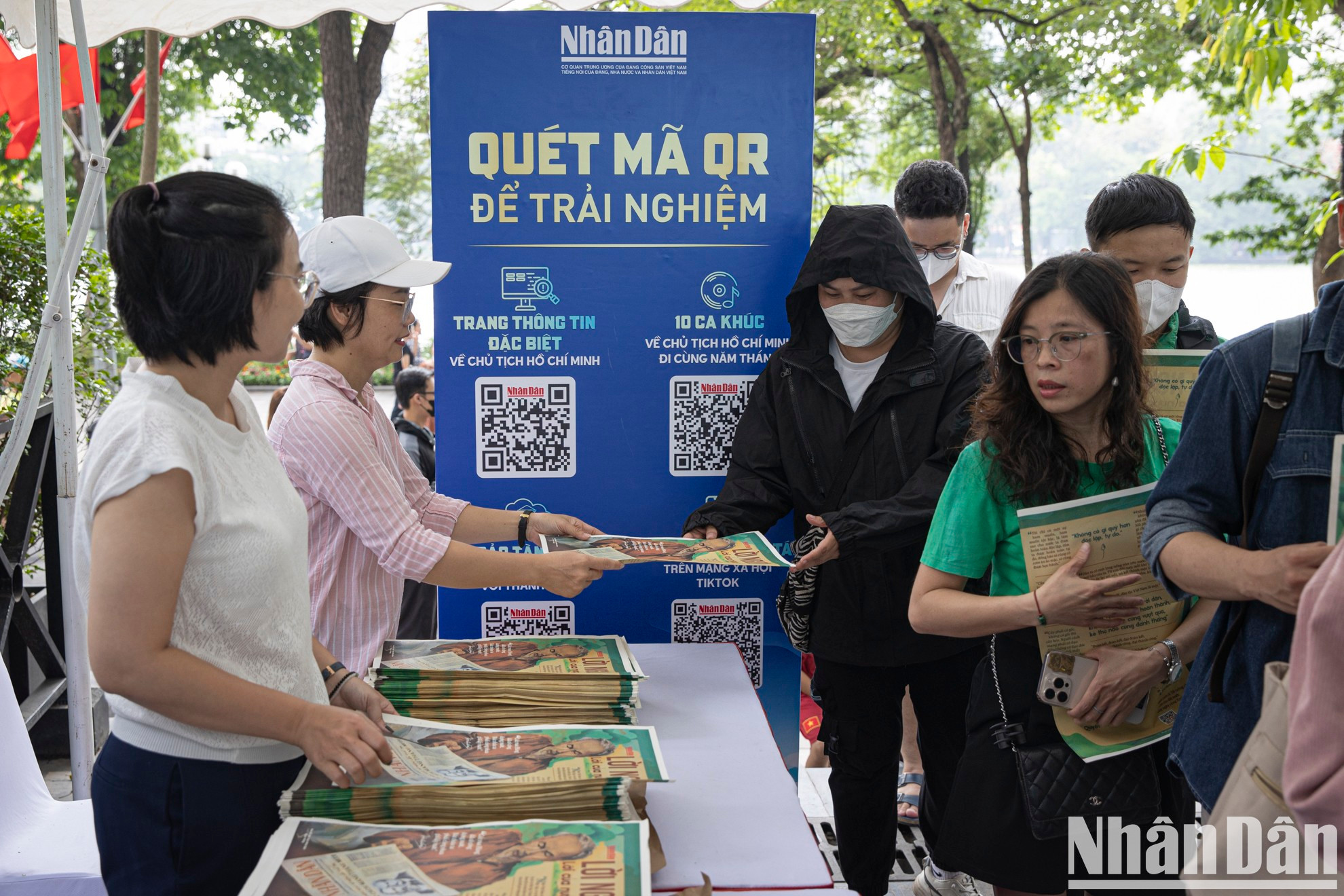 Los periodistas de Nhan Dan entregan la publicación especial a los lectores.