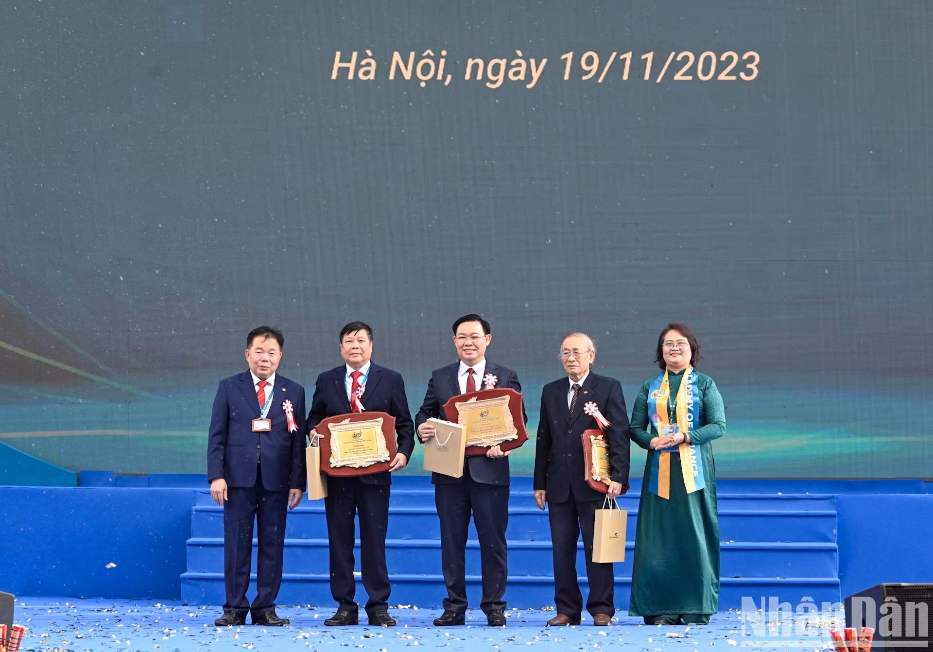 Líderes de la Academia de Finanzas entregan insignias y flores a los destacados profesores de la Academia.